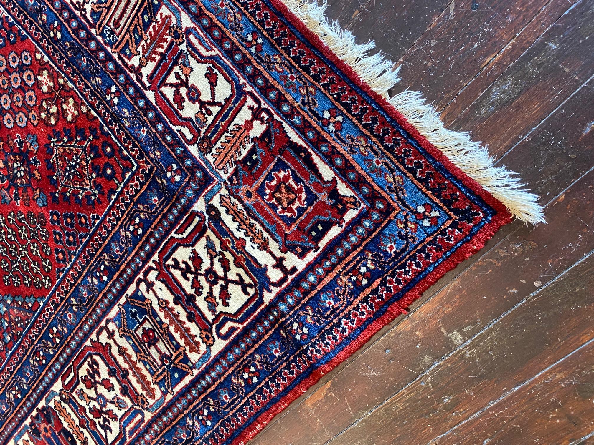 Indulge in the captivating beauty of the Early Twentieth Century Persian Joshegan Rug, a true gem in the world of Persian rug weaving. This exquisite rug showcases a beautiful and rich deep ensemble of colors, including burgundy, cream, blues, reds,
