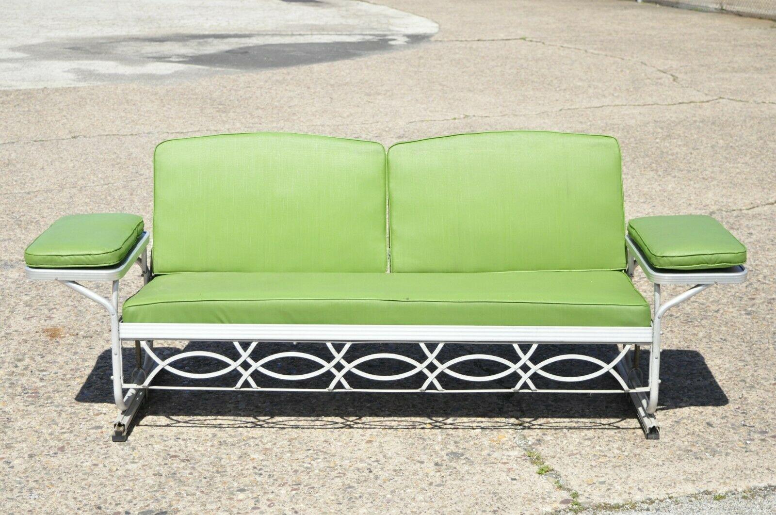 Vintage J.R. Bunting aluminum sleeper glider convertible sofa metal porch furniture. Item original reversible cushions, glider frame, aluminum construction, attached side tables, convertible frame from sofa to sleeper, very nice vintage item,
