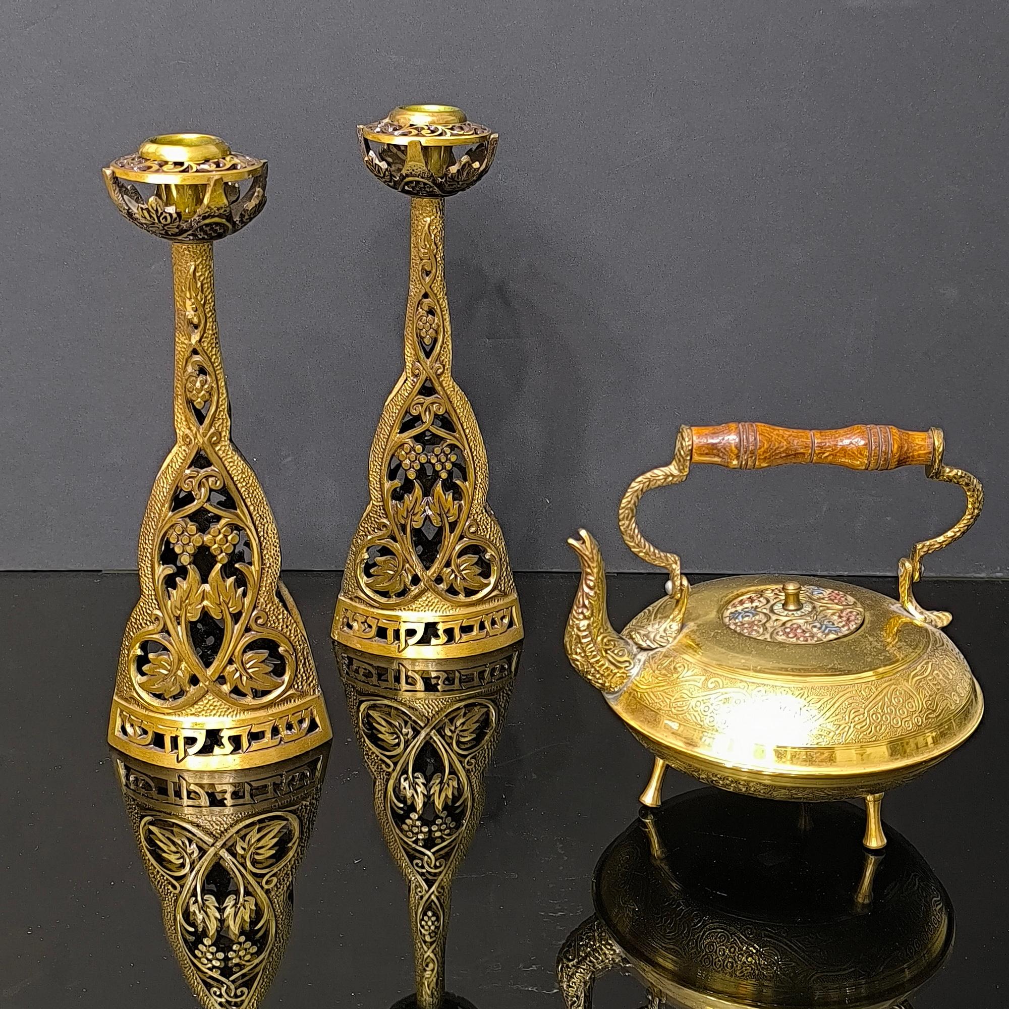 Arricchisci la tua casa o la tua collezione di Judaica con questa squisita coppia di candelieri vintage e un'esclusiva teiera in ottone.
I candelieri raggiungono un'altezza impressionante di 10 pollici e sono realizzati con dettagli intricati per