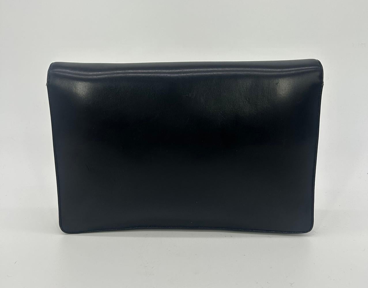 Vintage Judith Leiber Black Box Calf Leather Clutch in good condition. Smooth black box calf leather exterior trimmed with gold hardware and unique round orange resin detail along top front flap. Snap flap closure opens double flap style to a gold