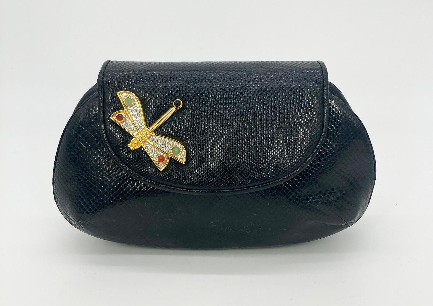 Judith Leiber Black Lizard Dragonfly Clutch in excellent condition. Black lizard exterior trimmed with a gold dragonfly embellished in crystals and gemstones. Back side slit pocket. Top flap with magnetic snap closure opens to a black nylon interior