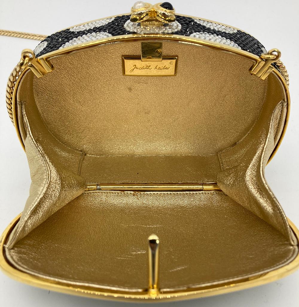 Judith Leiber Polka Dot Minaudiere in excellent condition. Black and clear swarovski crystal exterior trimmed with gold hardware and pearl and black stone button closure. Gold leather interior with attached gold chain shoulder strap. Overall