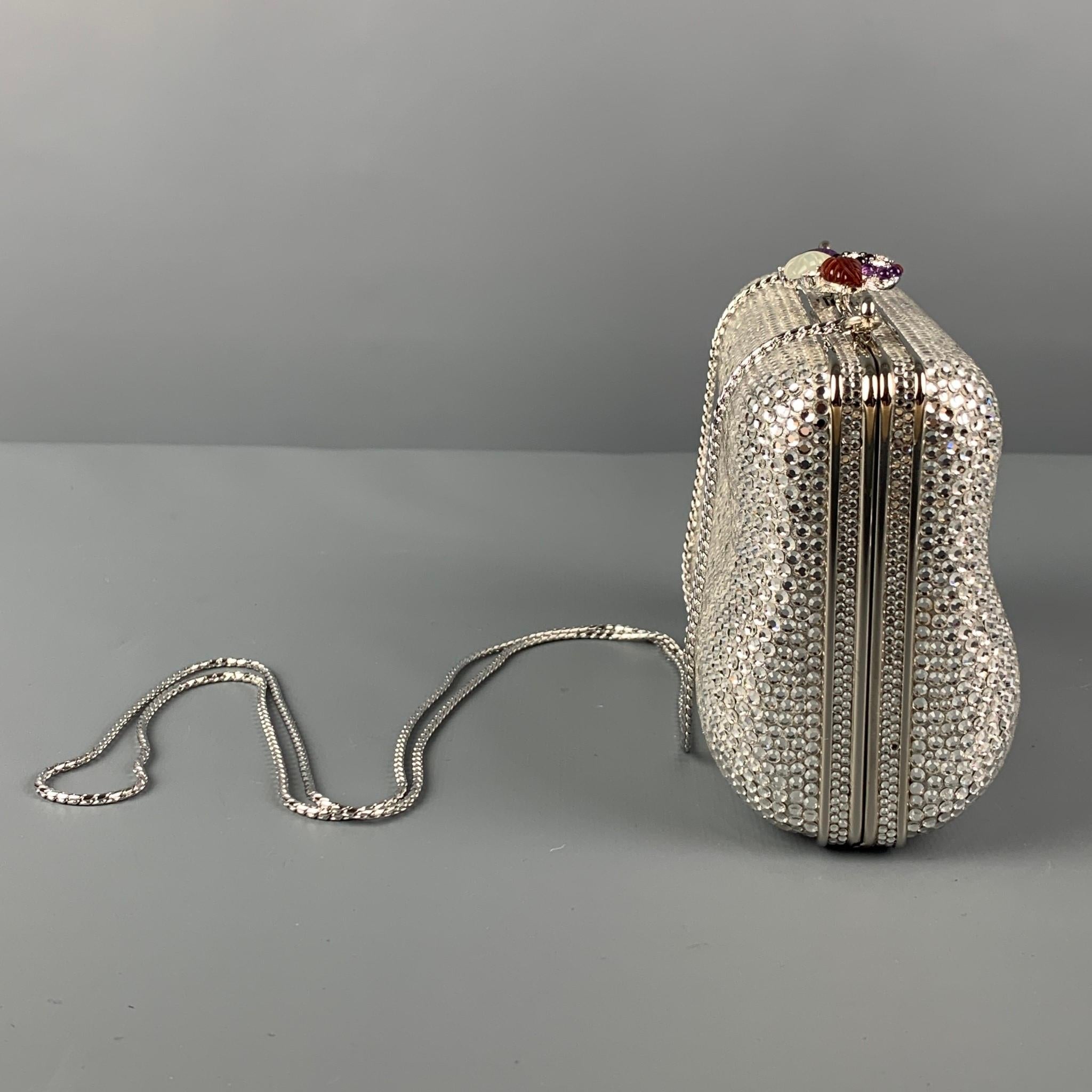 Vintage JUDITH LEIBER clutch comes in a silver rhinestones, chain link strap, and a floral clasp closure. Includes mini coin bag, mirror, and comb. Comes with box.

Very Good Pre-Owned Condition.

Measurements:

Length: 5.5 in.
Width: 2 in.
Height: