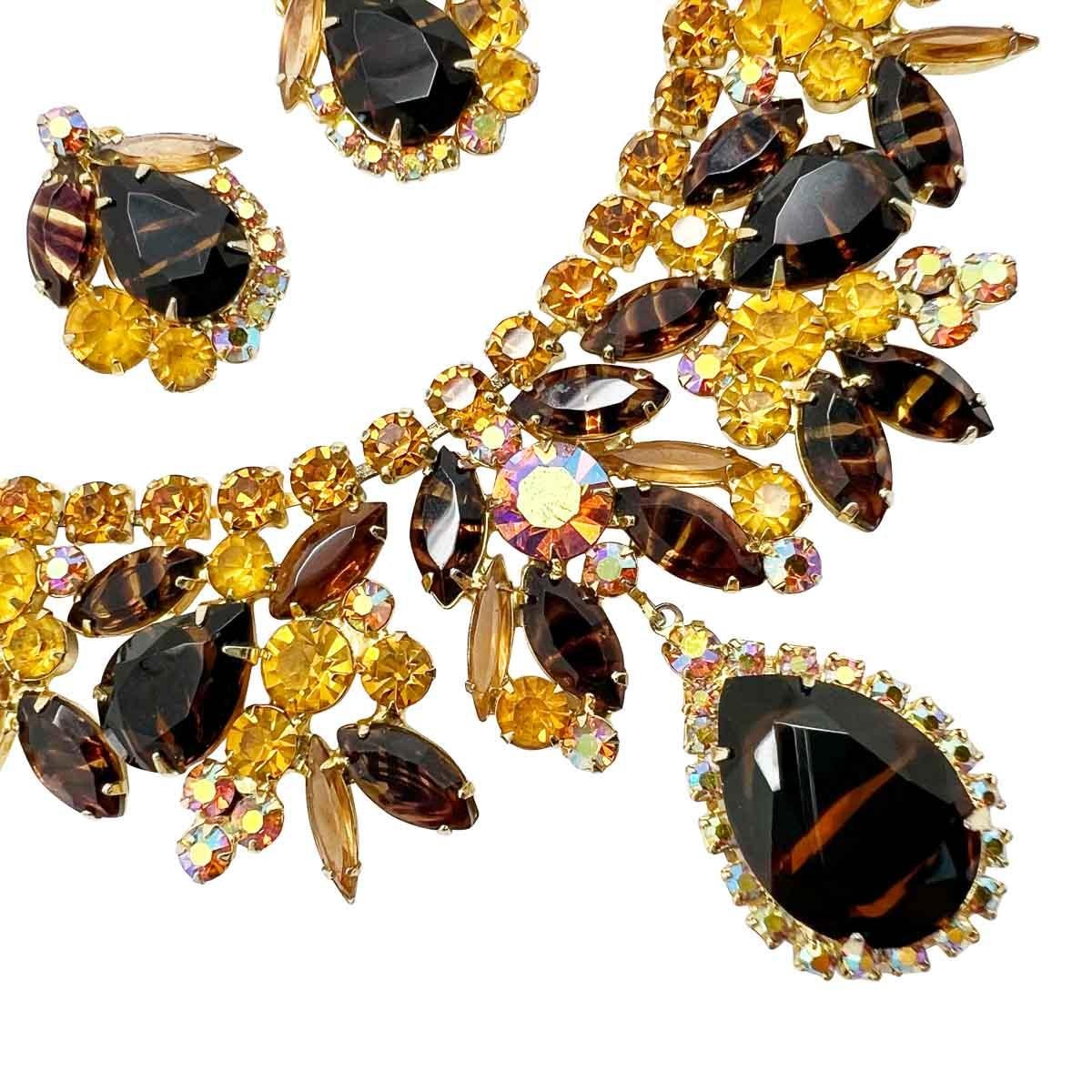 Un collier zébré Juliana d'une beauté fascinante, créé par les bijoutiers américains DeLizza & Elster dans les années 1950. Une palette de couleurs merveilleusement automnales de strass fantaisie orne un col de bout en bout et culmine dans un devant