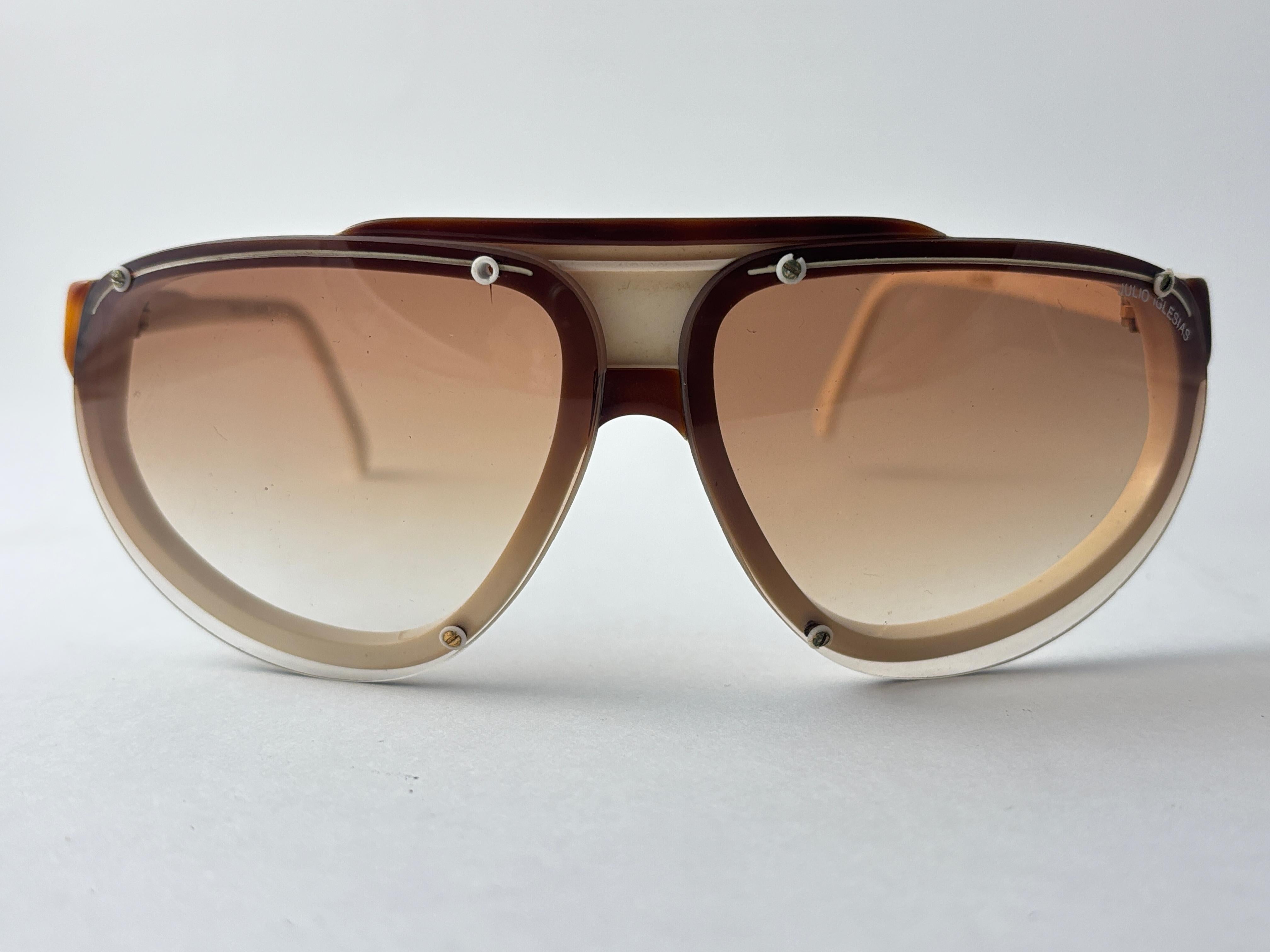 New Vintage Julio Iglesias Design Sonnenbrille braun und beige Frame Holding  Paar Gradientenlinsen. Dieses Paar zeigen kleinere Anzeichen von Verschleiß aufgrund von fast 40 Jahren Lagerung. 

Hergestellt in Frankreich.

Messungen


Vorderseite  14