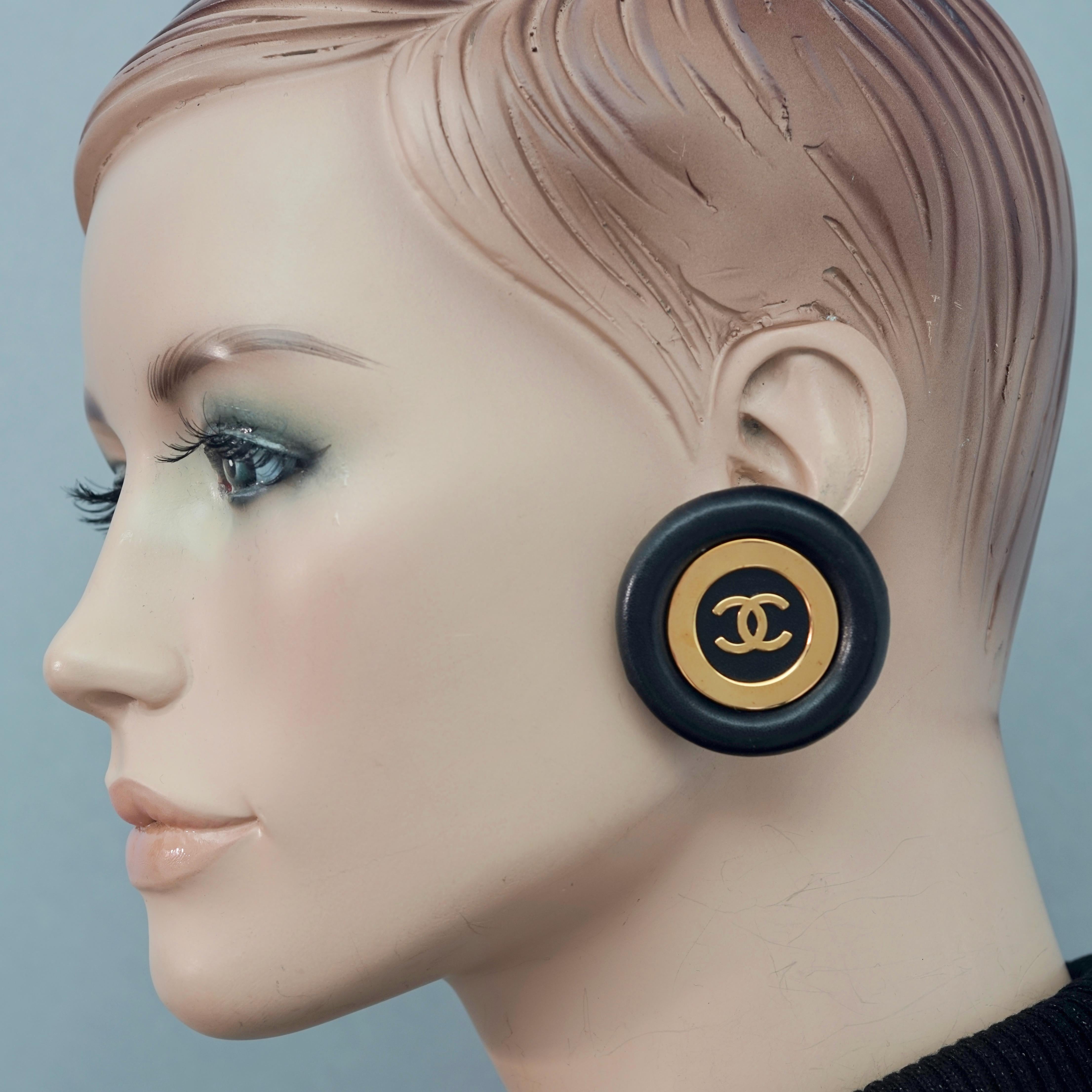 Vintage Jumbo CHANEL CC Logo Lambskin Leather Disc Earrings

Measurements:
Height: 1.81 inches (4.6 cm)
Width: 1.81 inches (4.6 cm)
Weight per Earring: 21 grams

Features:
- 100% Authentic CHANEL.
- Jumbo black lambskin leather disc earrings.
- CC