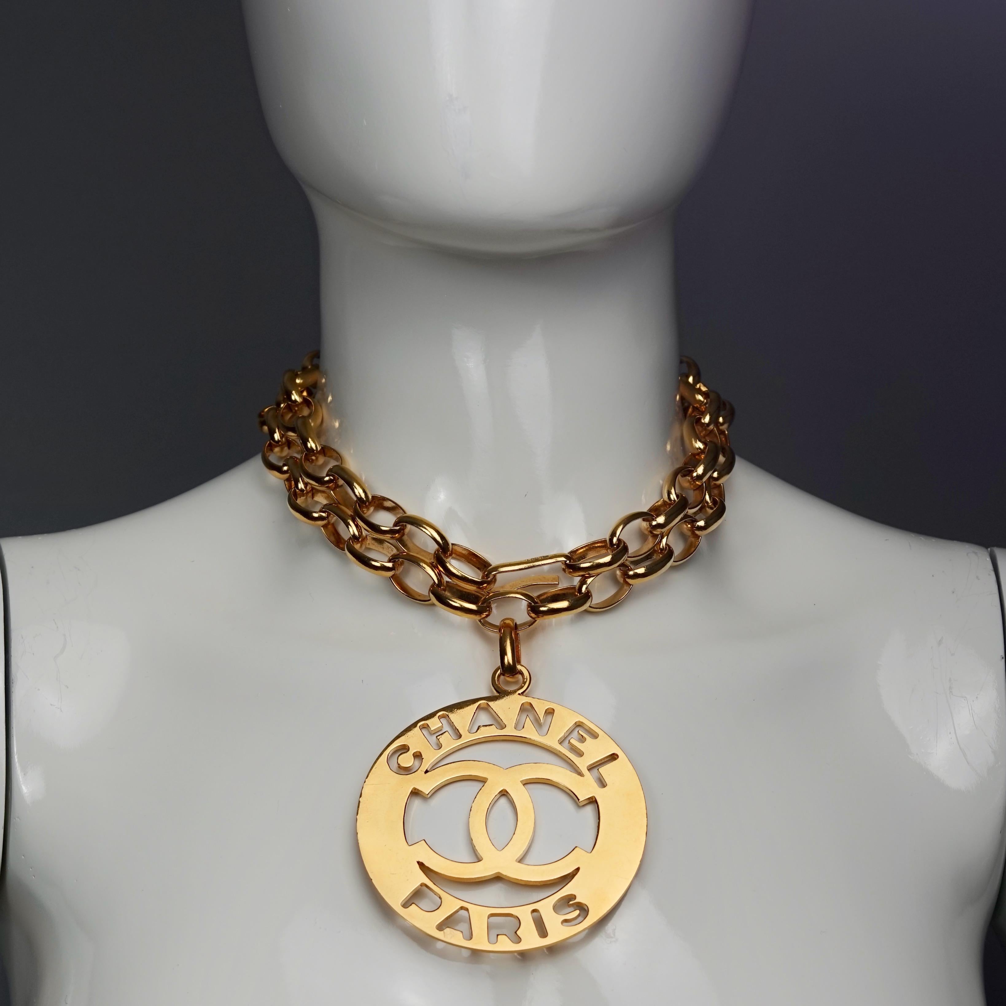 Vintage Jumbo CHANEL PARIS Cutout Logo Medallion Necklace
As seen on Kim Kardashian. 

Measurements:
Height: 2.95 inches (7.5 cm) excluding the pendant bail
Width: 2.95 inches (7.5 cm)
Chain: 31.89 cm (81 cm)

Features:
- 100% Authentic CHANEL.
-