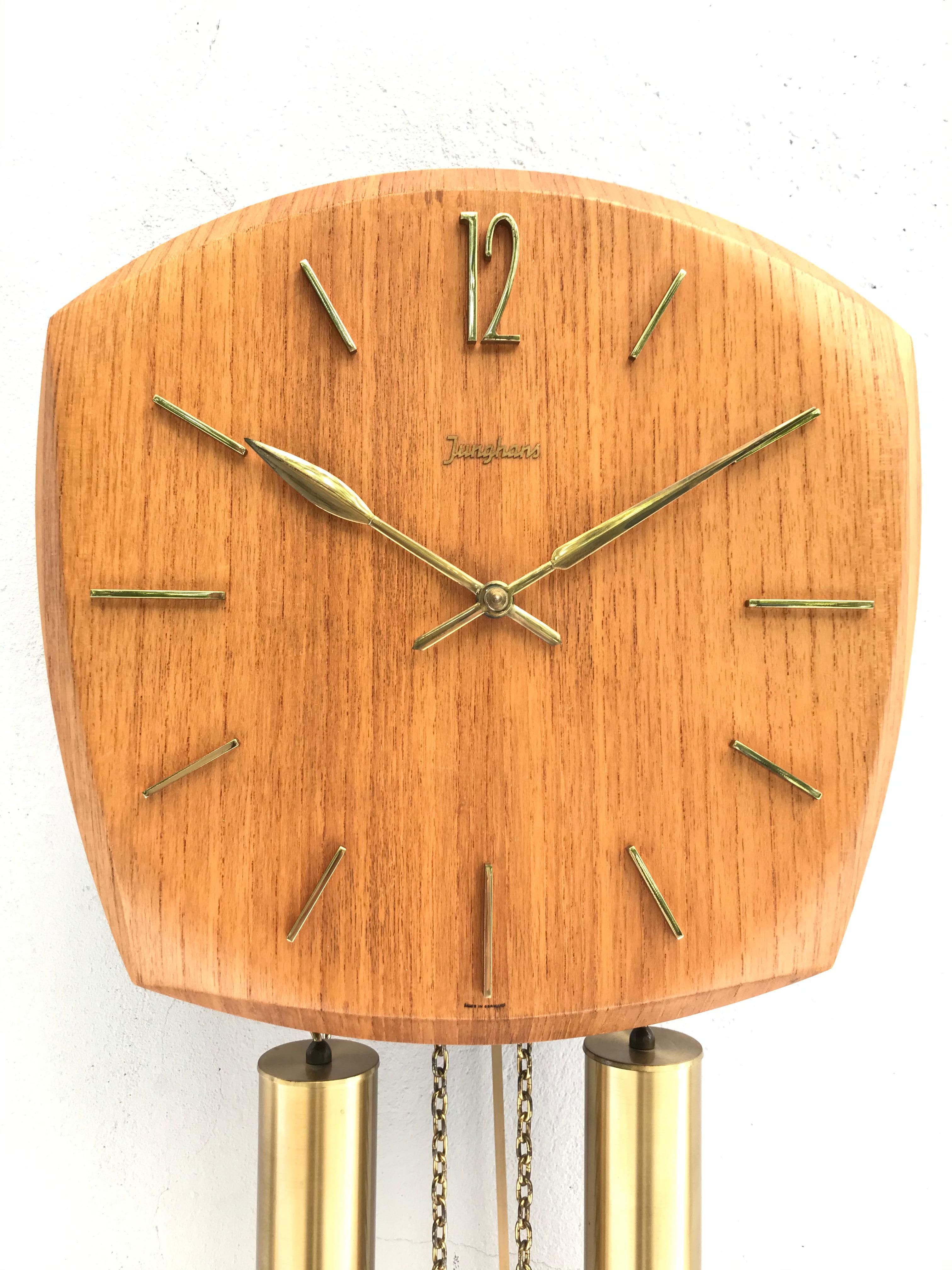 Vintage Junghans pendulum wall clock from the 1960s in form pressed teak veneer with brass fittings.
In lovely working condition and with chimes on the half and whole hour that can be switched off if so desired.
 