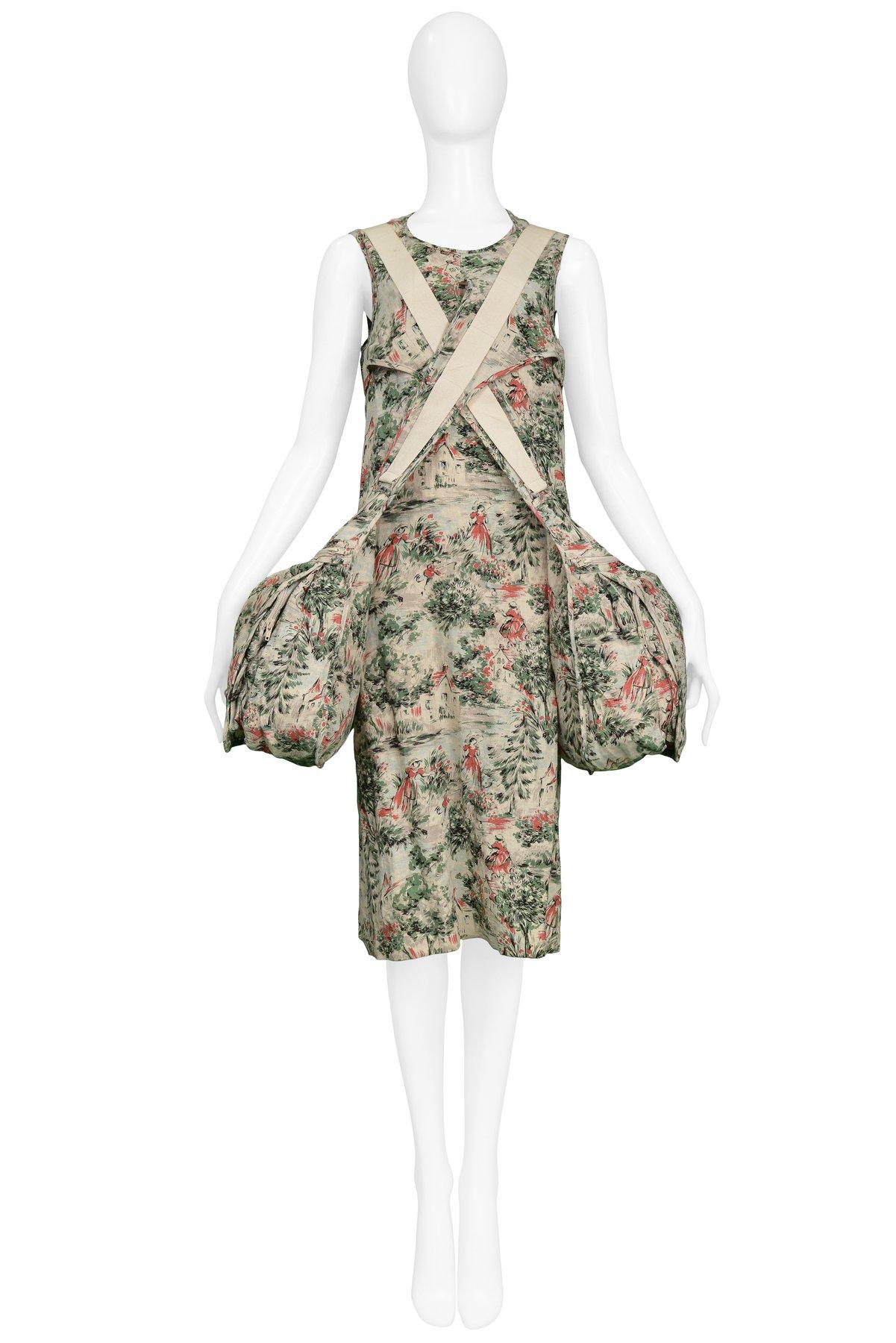 Resurrection Vintage is excited to offer a vintage Junya Watanabe linen pictorial print parachute double bag dress. The parachute dress features a pink, green, and black country scene print on an off-white background, tank sleeves, a keyhole back,
