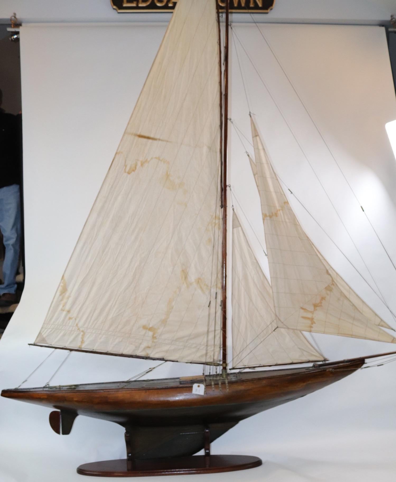 Vintage K class pond yacht with sleek hull, heavy lead keel, brass fittings and a full suit of linen sails. Model weighs 69 pounds. (X-1)