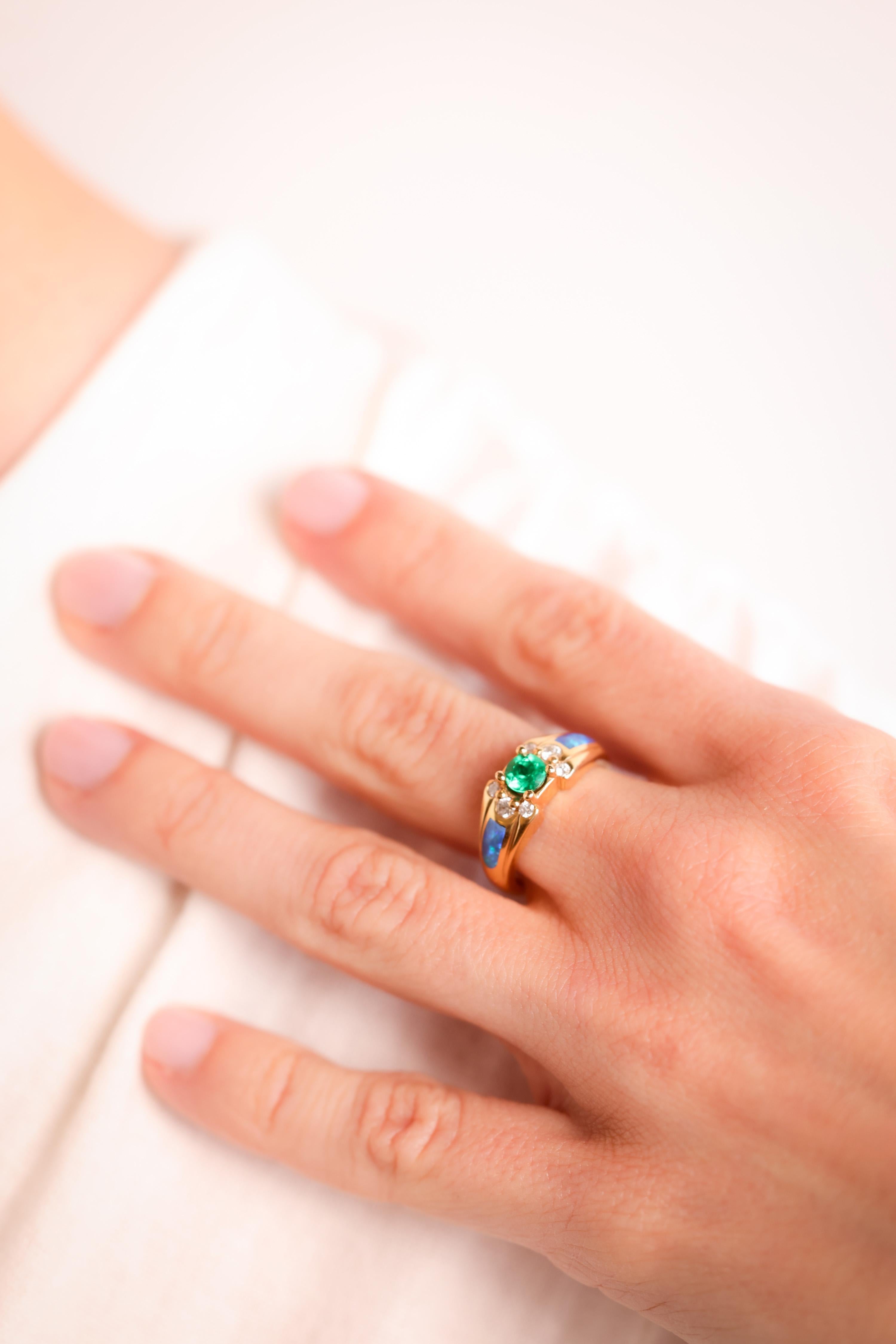 Marke: Kabana
Mittelstein: Smaragd
Schnitt: Rund 
Gewicht: Ungefähr 0,5 Karat
Farbe: Grün
Akzentuierungsstein: 6 Diamanten
Schliff: Runder Brillant
Gewicht: Ungefähr 0,17 Karat
Farbe: H
Klarheit: SI
Akzentuierungsstein: 2 Opale
Metall: 14K
