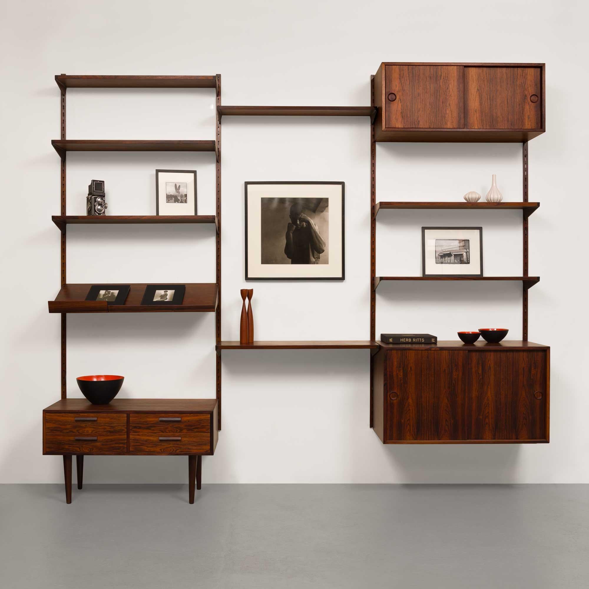This exquisite vintage FM Reolsystem shelving system, designed by the renowned Danish designer Kai Kristiansen, is a true masterpiece of mid-century modern design. Crafted from richly grained rosewood, the system showcases the elegance, innovation,