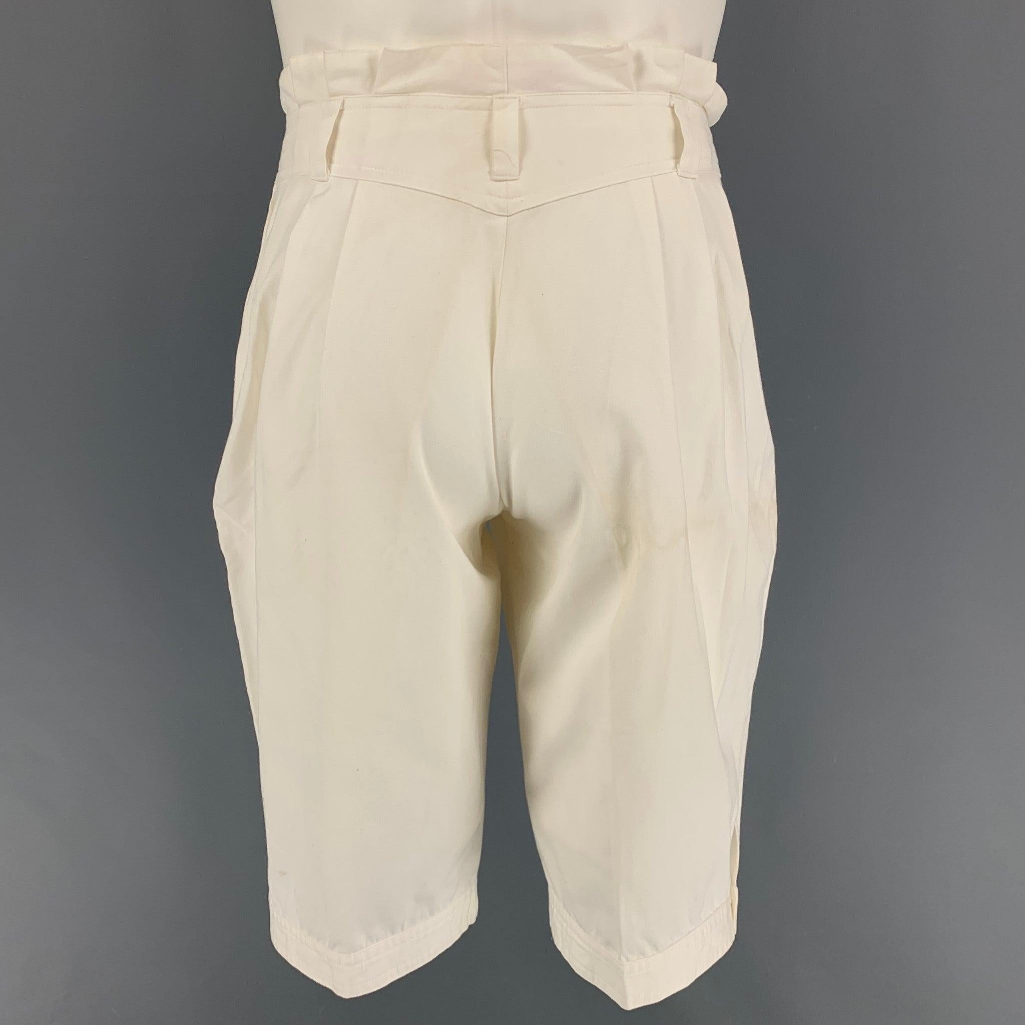 Vintage KANSAI YAMAMOTO shorts comes in a white cotton featuring a pleated style, ruffled trim, snap button details, zip fly, and a double snap button closure. Made in Japan.
Good Pre-Owned Condition. Minor mark at leg.  

Marked:   28