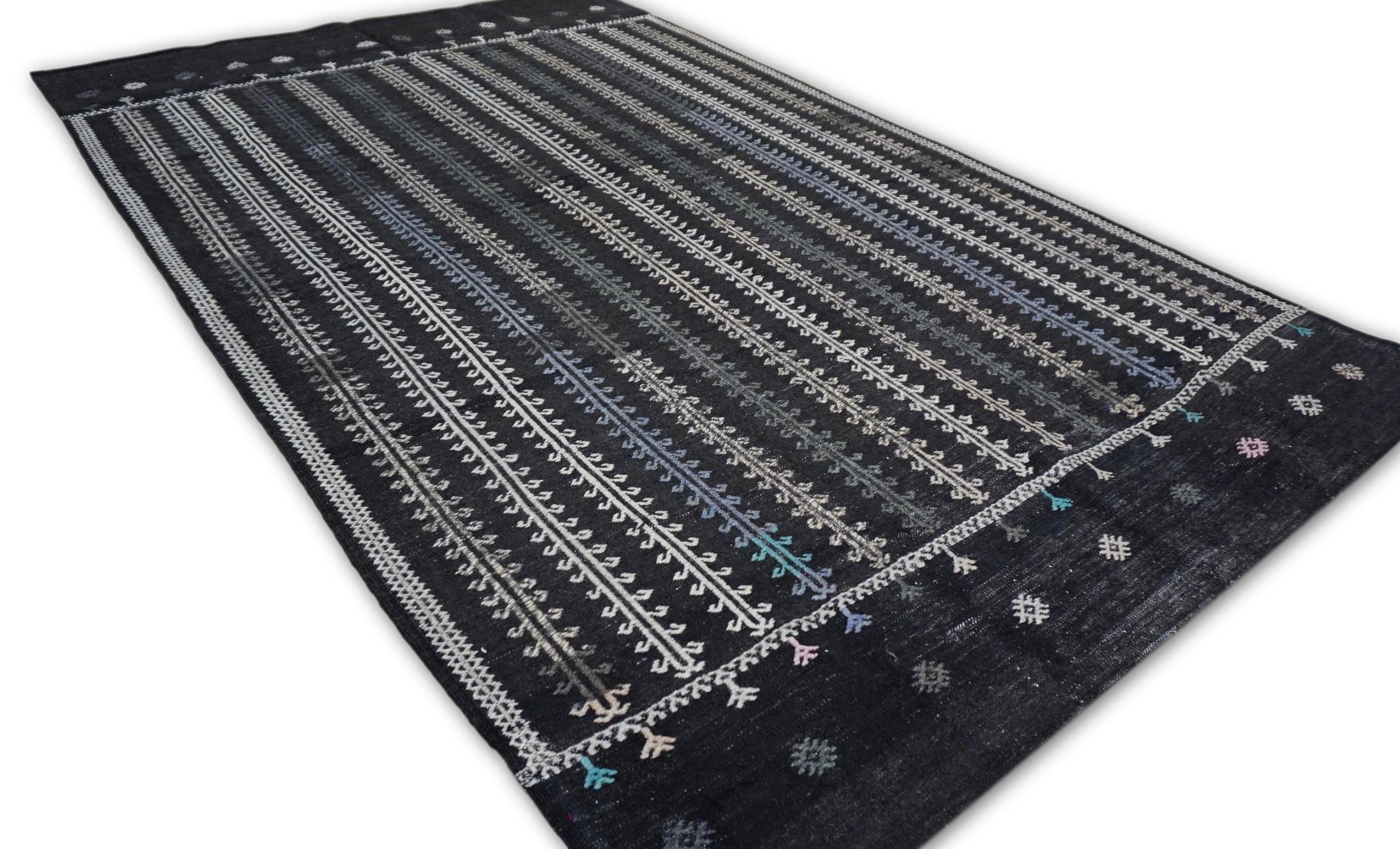Dieser Jahrgang  Der Kelimteppich aus Wolle zeigt ein atemberaubendes Zusammenspiel von traditioneller Handwerkskunst und moderner Eleganz. Der tiefe Hintergrund ist mit sorgfältig gewebten vertikalen Rankenmotiven in zartem Elfenbein und subtilen