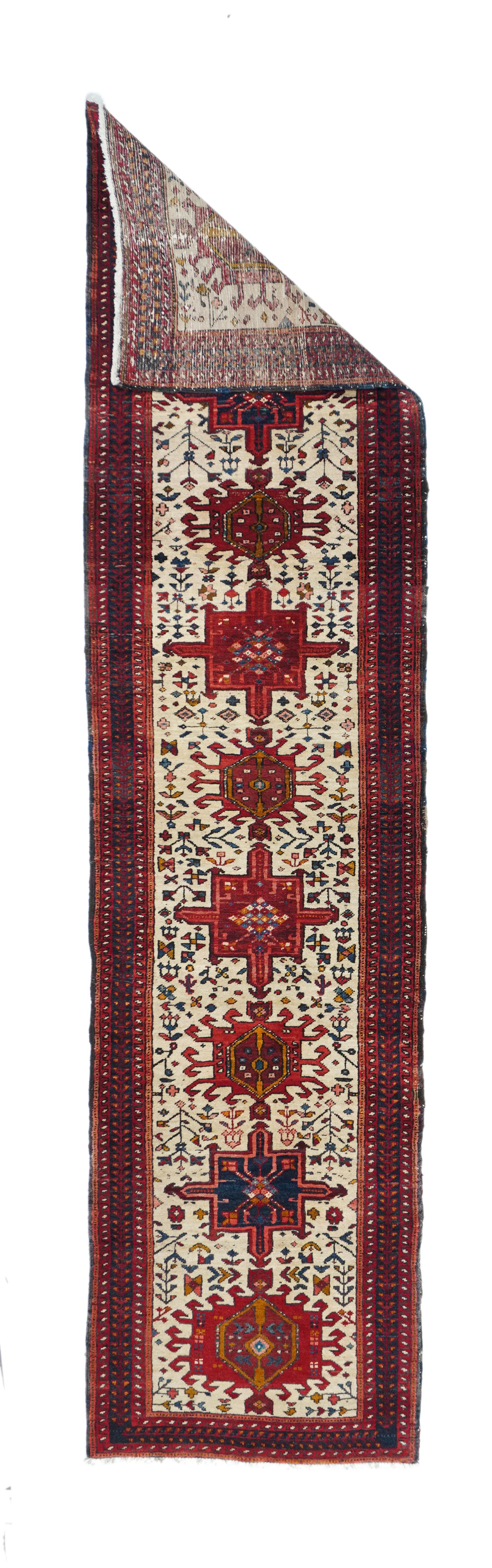 Vintage Karajeh rug 2'4'' x 9'9''. This NW Persian village kenare (runner) shows nine characteristic motives vê blue and red octogrammes, red hooked hexagons and smaller hooked polygons - all on the sandy cream field with a supporting scatter of