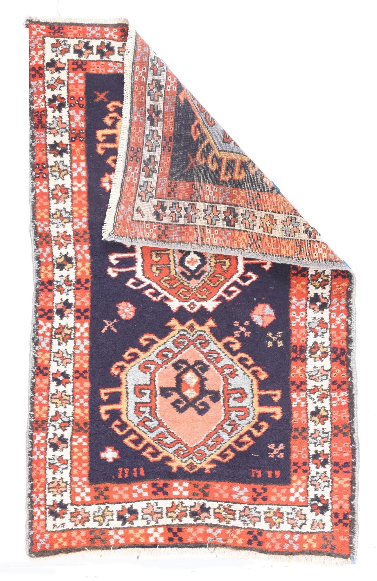 Vintage Karajeh Rug 3'2'' x 5'. The deep royal blue ground hosts three nested vertically pinched octagonal hooked medallions in sky blue, rust red, straw, dark blue and ecru. Quincunxes in field continue in the rust minor borders, flanking an ecru
