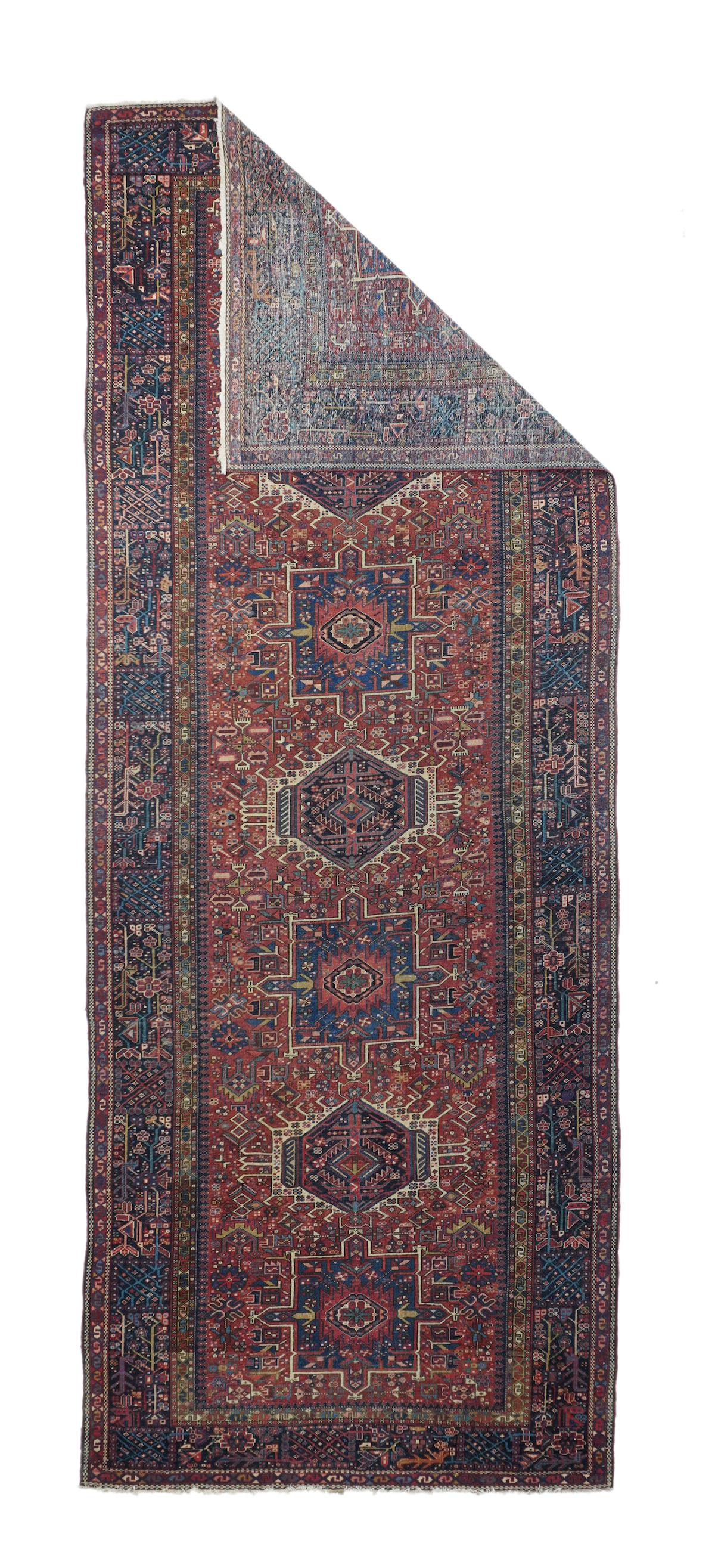 Vintage Karajeh Rug 4'11'' x 13'. The tomato field features an alternation of seven blue pointed squares and cream hook fringed hexagons. Dense scatter for geometric flowers, stars and rosettes. Dark blue border of floret squares, herringbone leaves