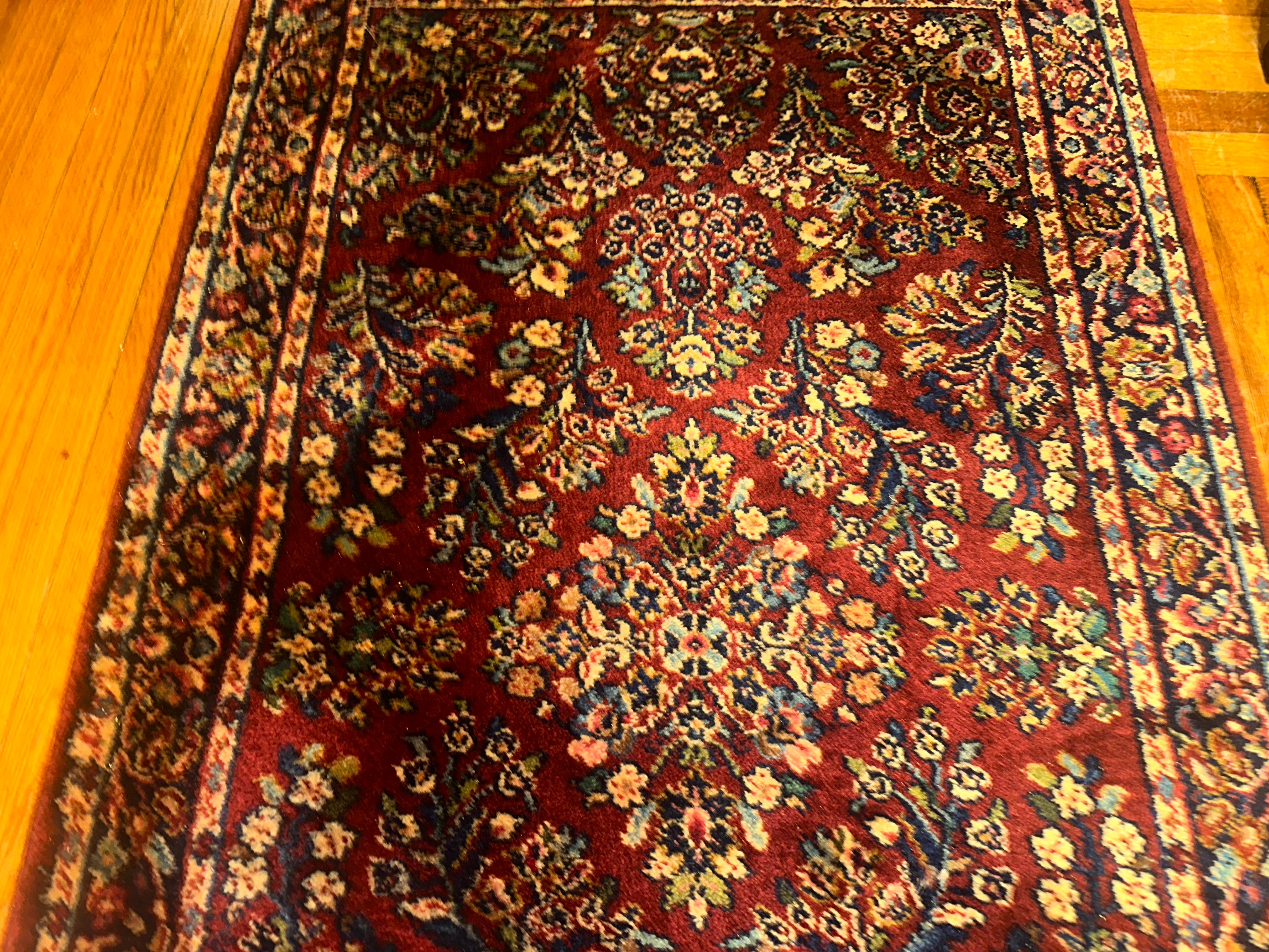 This is a vintage Karastan rug with a red sarough design.  Made in the 1980s, the rug is in excellent condition with 100% wool pile. (In the 1980s, the company was the original Karastan.. see below) There are no stains, no cuts, and no problems. The