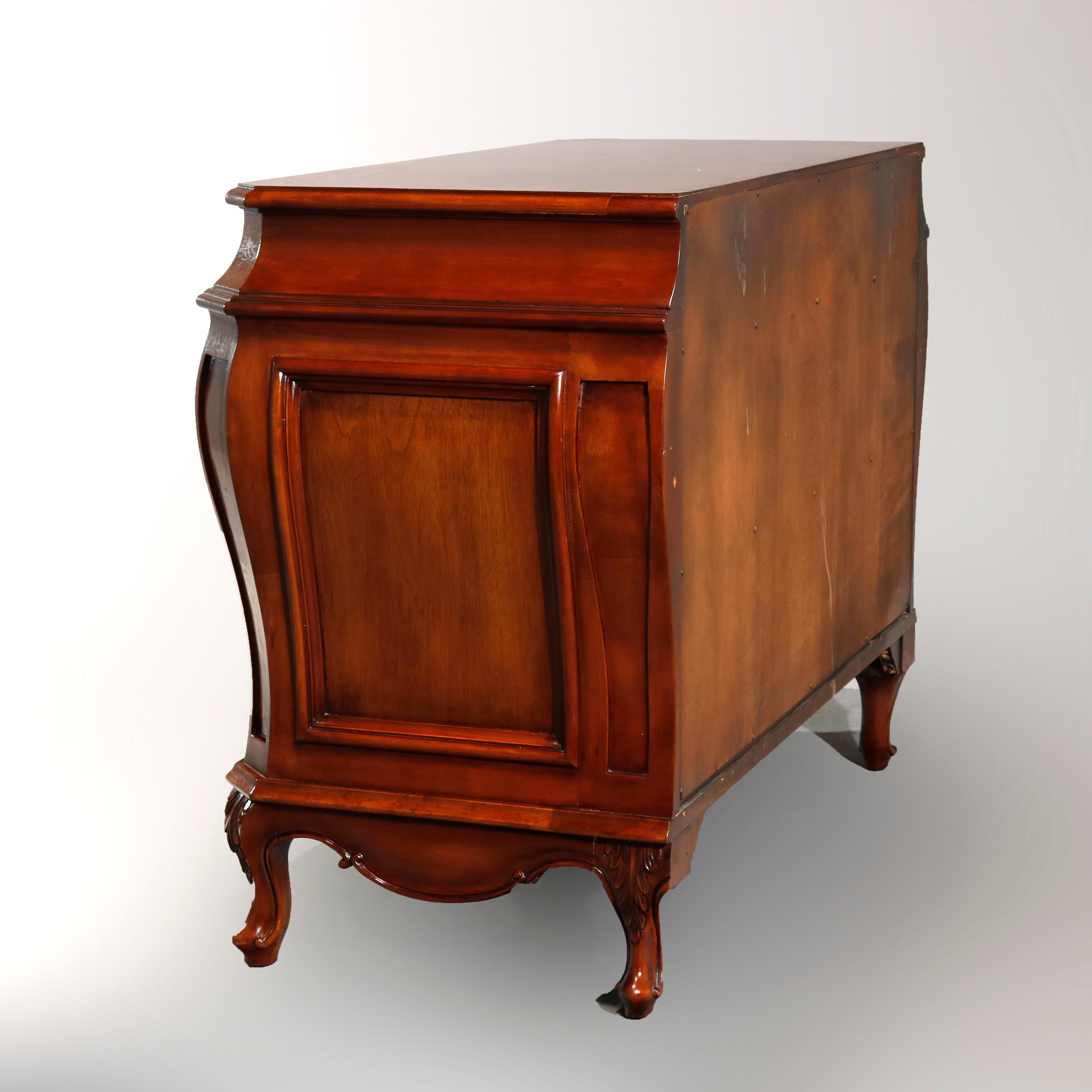 A vintage Continental style chest of drawers by Karges Furniture offers stylized bombe form with upper frieze drawer over two long drawers each having burl facing and cast foliate pulls, raised on cabriole legs with carved acanthus knees, maker