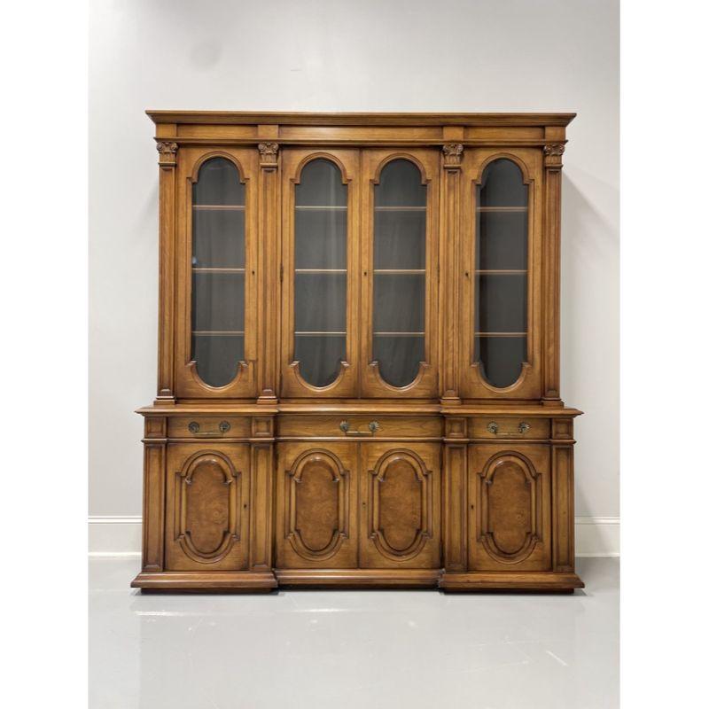 A vintage Mediterranean style breakfront china cabinet by Karges, of Evansville, Indiana, USA. Walnut with burl wood lower cabinet door fronts and brass hardware. Upper cabinet has three separate areas with dual center and flanking side arched