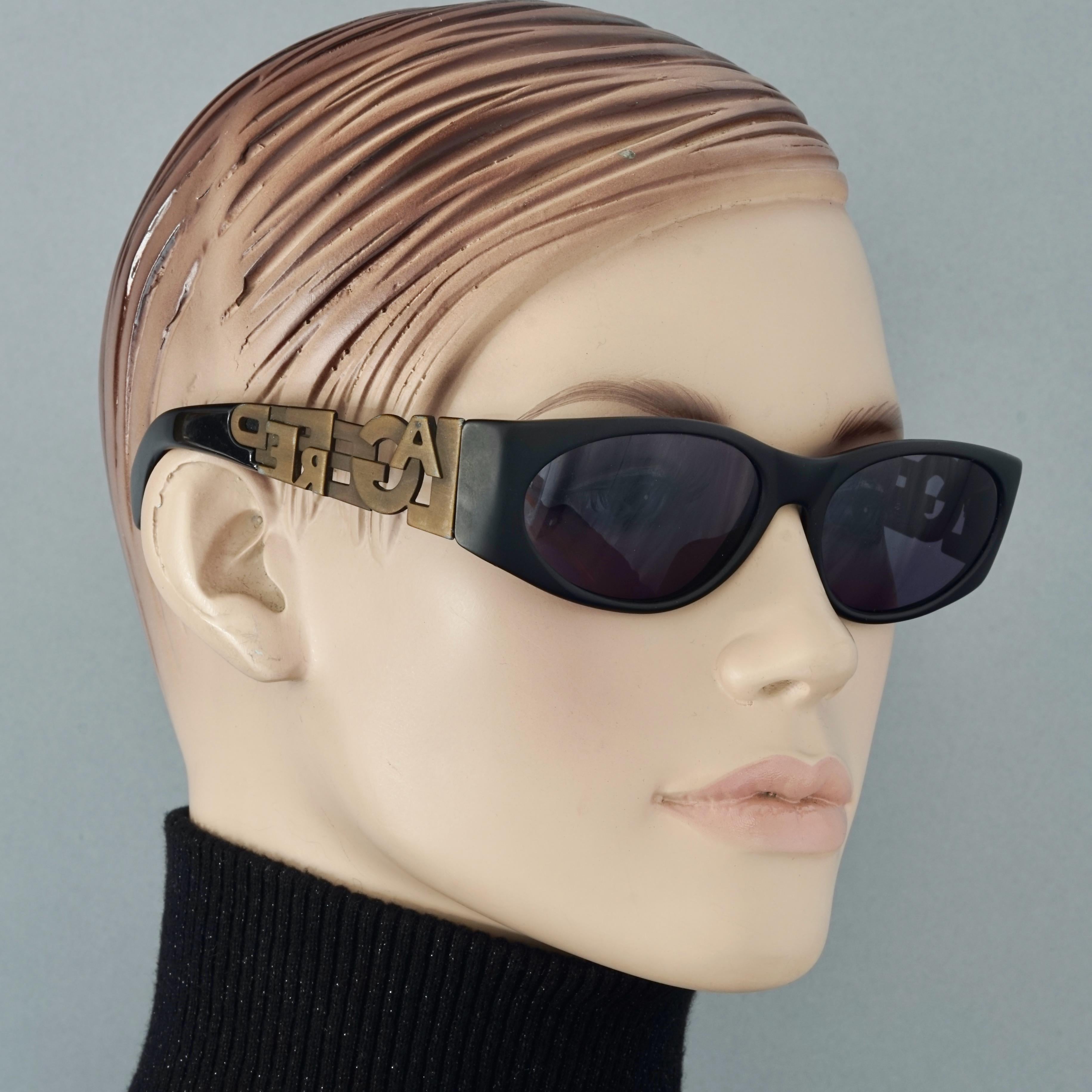 Vintage KARL LAGERFELD Bronze Spelled Logo Sunglasses

Measurements:
Frame Height: 1.57 inches (4 cm)
Frame Width: 5.70 inches (14.5 cm)
Temples: 4.52 inches (11.5 cm)

Features:
- 100% Authentic KARL LAGERFELD. 
- Black sunglasses with bronze tone