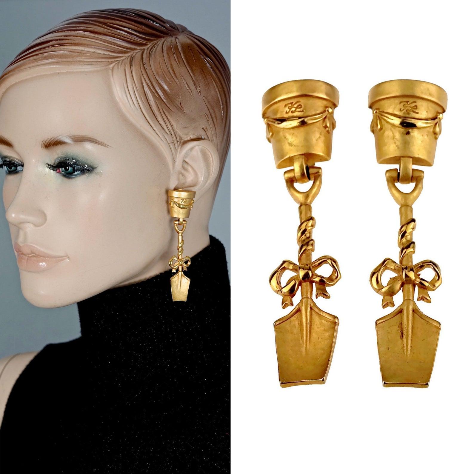 Vintage KARL LAGERFELD Flower Pot Shovel Gardening Novelty Earrings

Measurements:
Height: 3.07 inches (7.8 cm)
Width: 0.70 inch (1.8 cm)
Weight: 17 grams

Features:
- 100% Authentic KARL LAGERFELD.
- Garden motif earrings with flower pot and