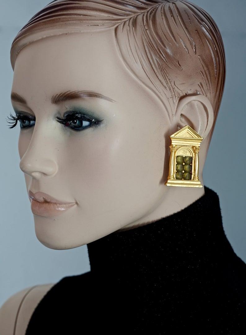 Vintage KARL LAGERFELD Greek Temple Door Earrings

Measurements:
Height: 1.85 inches (4.7 cm)
Width: 1.14 inches (2.9 cm)
Weight per Earring: 20 grams

Features:
- 100% KARL LAGERFELD.
- Greek temple door motif with faceted glass stones at the