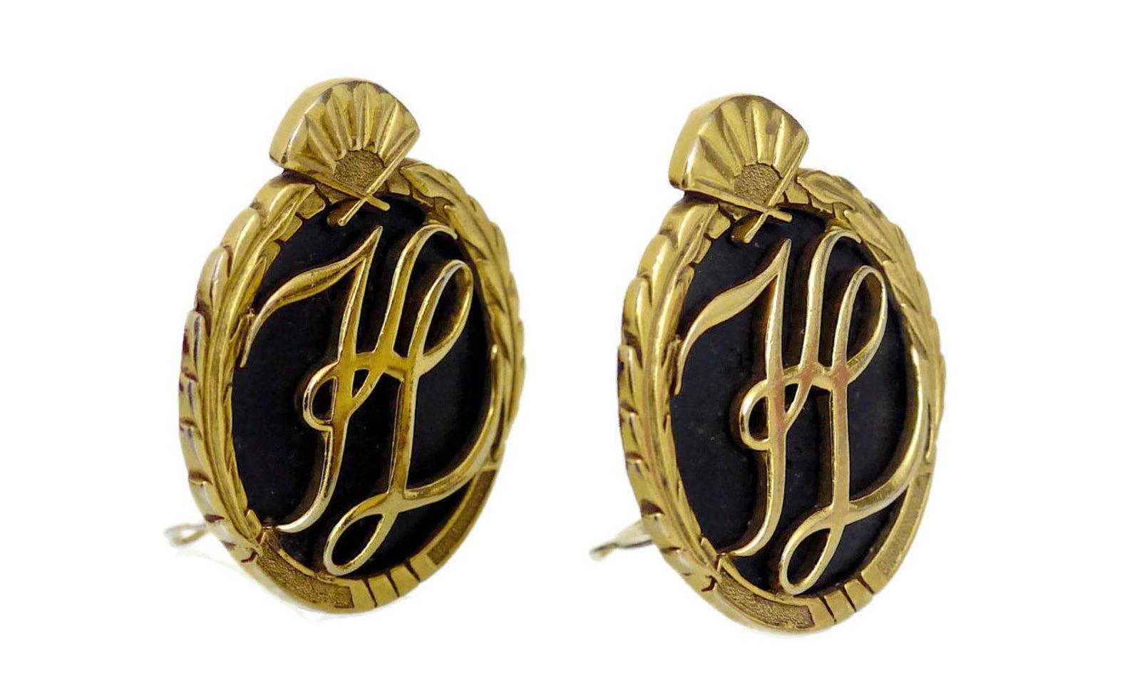 Vintage Karl Lagerfeld Iconic Logo Earrings

Measurements:
Height: 1 6/8 inches
Width: 1 5/8 inches

Features:
- 100% Authentic KARL LAGERFELD.
- Embossed KL initials at the center.
- Ornate detailing at the sides and fan at the top.
- Black