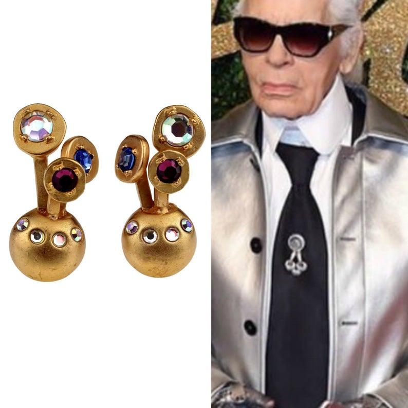 Vintage KARL LAGERFELD Jewelled Spherical Earrings

Measurements:
Height: 1.57 inches (4 cm)
Width: 0.78 inch (2 cm)
Weight per Earring: 13 grams

Features:
- 100% Authentic KARL LAGERFELD.
- Jewelled spherical earrings embellished with colourful