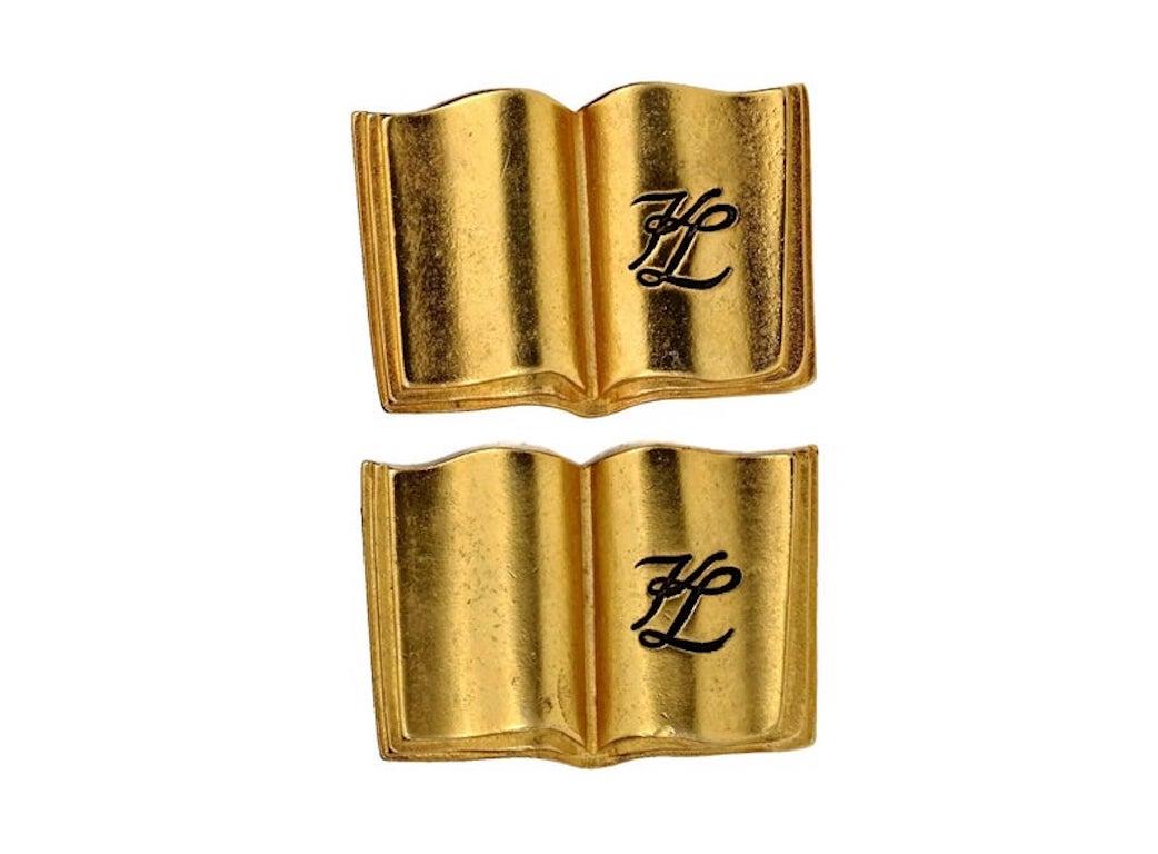 Vintage KARL LAGERFELD KL Logo Book Novelty Earrings

Measurements:
Height: 1.38 inches (3.5 cm)
Width: 1.02 inches (2.6 cm)
Weight per Earring: 15 grams

Features:
- 100% Authentic KARL LAGERFELD.
- Opened book motif earrings with engraved KL.
-