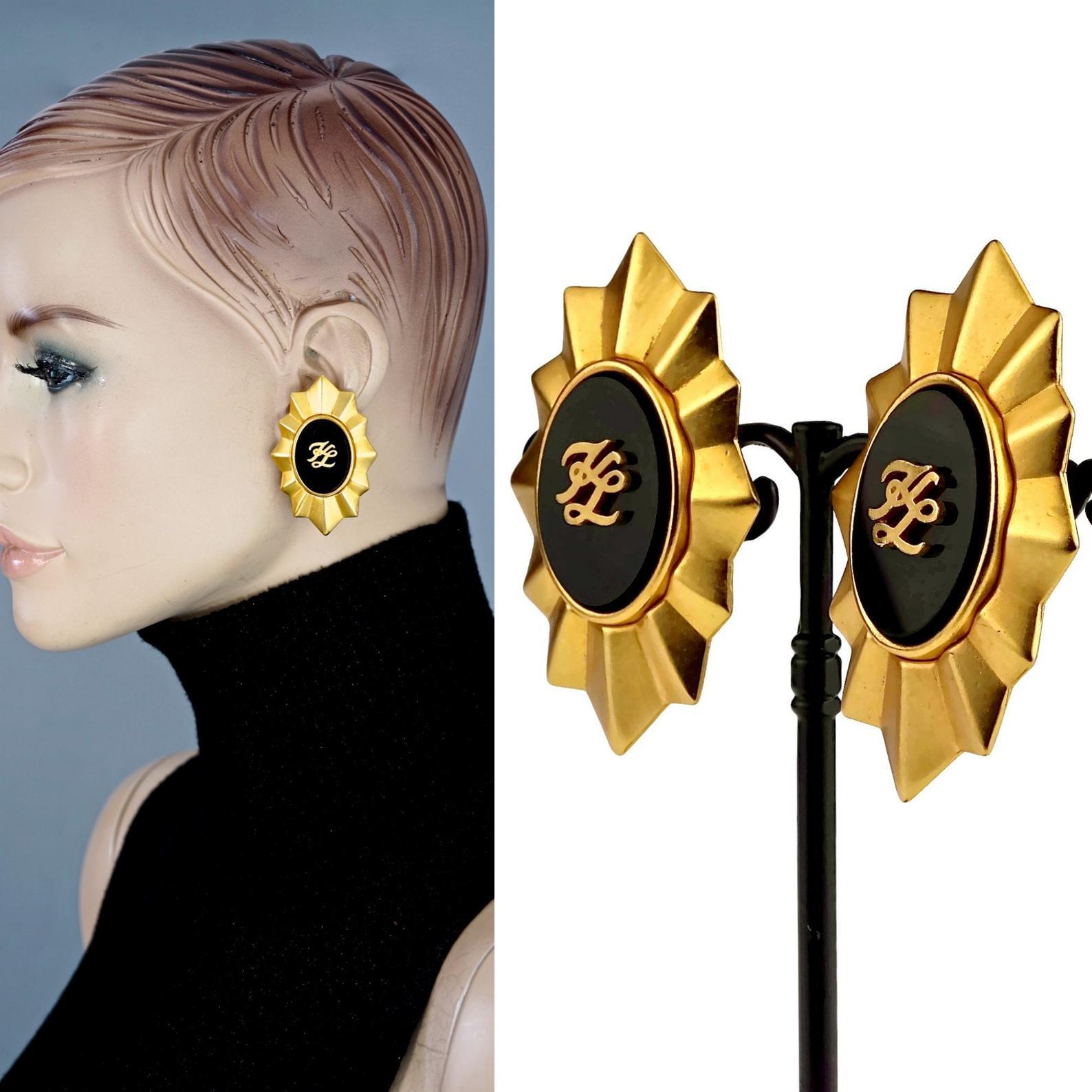 Vintage Karl Lagerfeld KL Logo Sun Earrings

Measurements:
Height: 2.12 inches (5.4 cm)
Width: 1.33 inches (3.4 cm)
Weight per Earring: 21 grams

Features:
- 100% Authentic KARL LAGERFELD.
- Sun motif earrings with embossed KL initials on a black