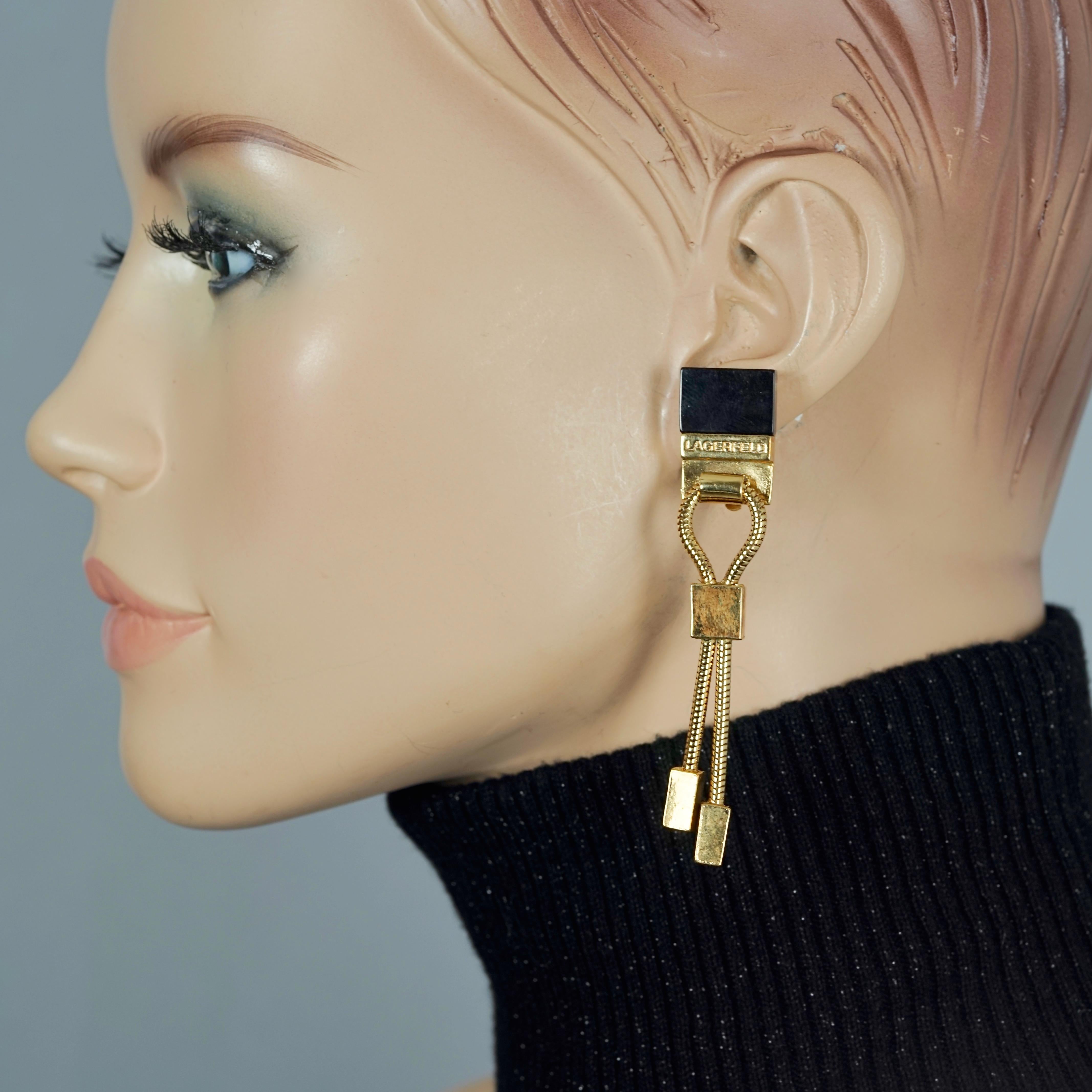 Vintage KARL LAGERFELD Logo Black Resin Hanging Chain Earrings

Measurements:
Height: 3.14 inches (8 cm)
Width: 0.59 inch (1.5 cm)
Weight per Earring: 13 grams

Features:
- 100% Authentic KARL LAGERFELD.
- Dangling earrings with LAGERFELD logo,