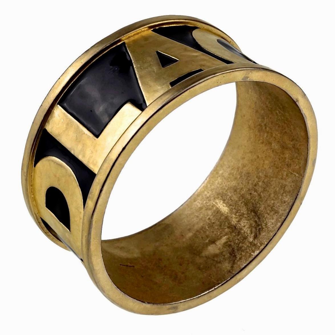 Vintage KARL LAGERFELD Spelled Enamel Cuff Bracelet

Measurements:
Height: 1.3 inches (3.3 cm)
Inner Circumference: 7.87 inches(20 cm)

Features:
- 100% Authentic KARL LAGERFELD.
- Chunky bracelet cuff in matte gold tone and black enamel .
- Raised