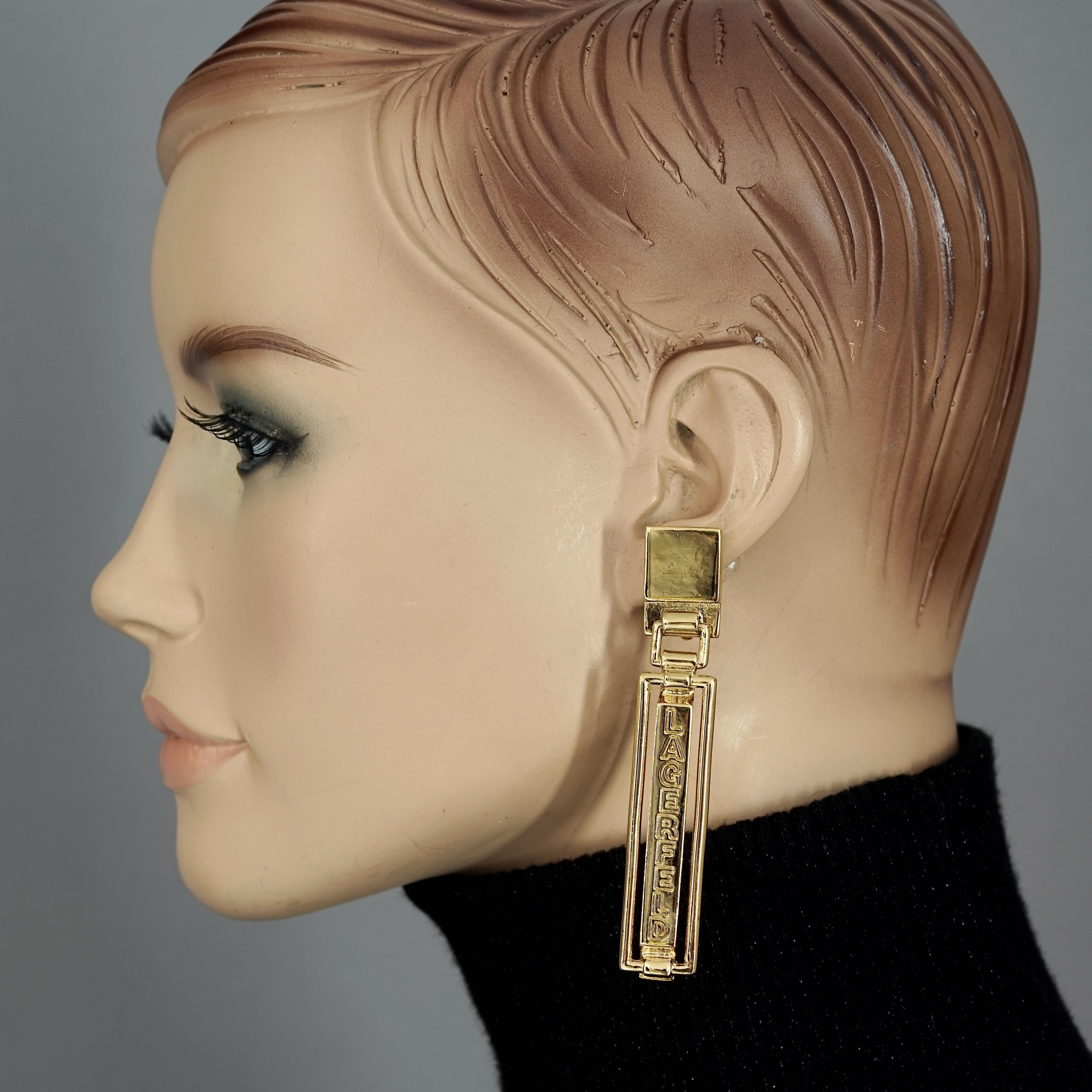 Vintage KARL LAGERFELD Spelled Out Dangling Earrings

Measurements:
Height: 3.35 inches (8.5 cm)
Width: 0.59 inch (1.5 cm)
Weight per Earring: 21 grams

Features:
- 100% Authentic KARL LAGERFELD.
- Dangling rectangular earrings with spelled out