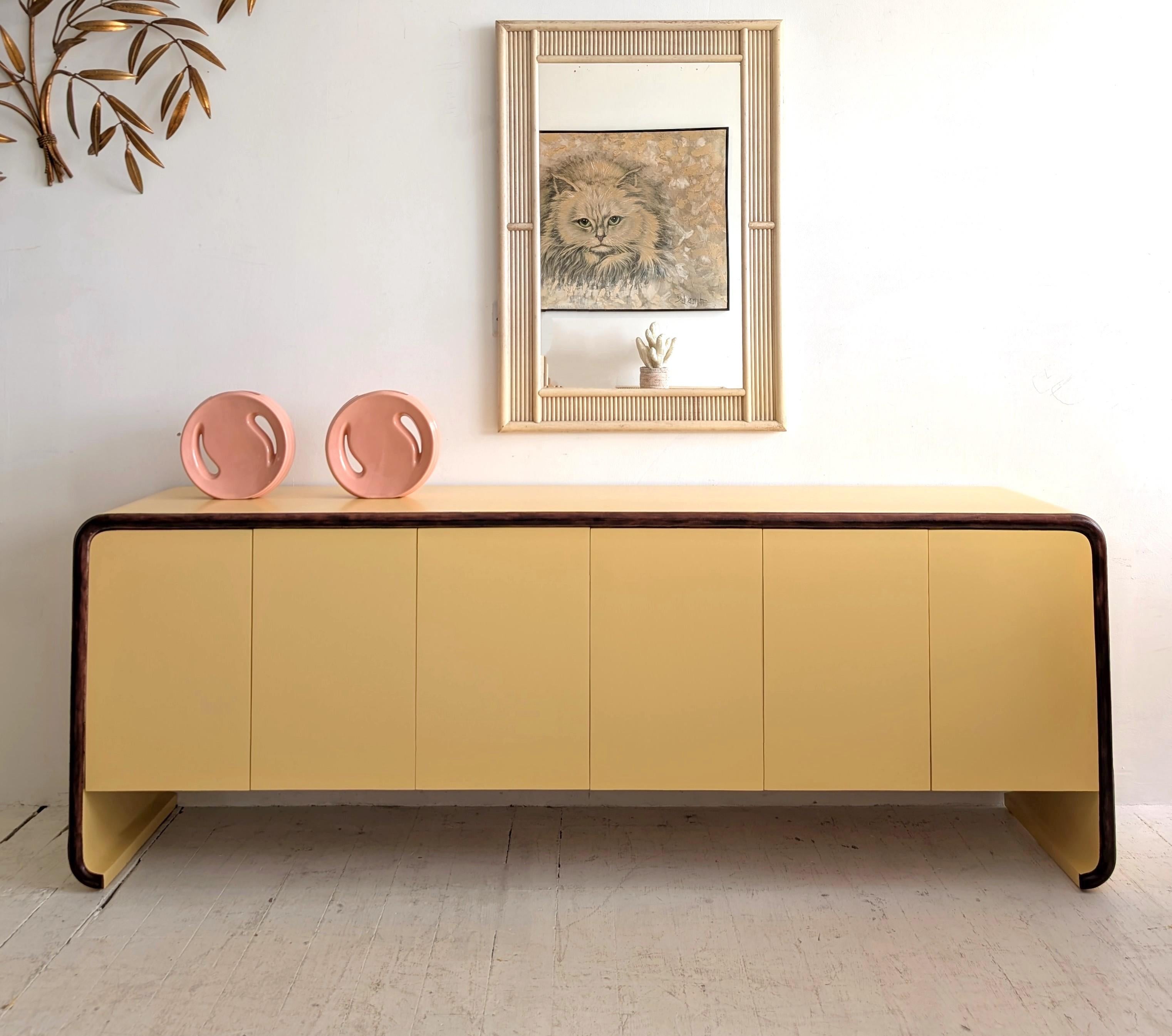 Credenza a cascata lunga e sottile in stile postmoderno di Karl Springer, USA anni '80.  Rifiniture in Wood sul bordo anteriore (noce?). Le ante a pressione si aprono su ripiani a destra e a sinistra e su 2 piccoli cassetti nel vano centrale.  