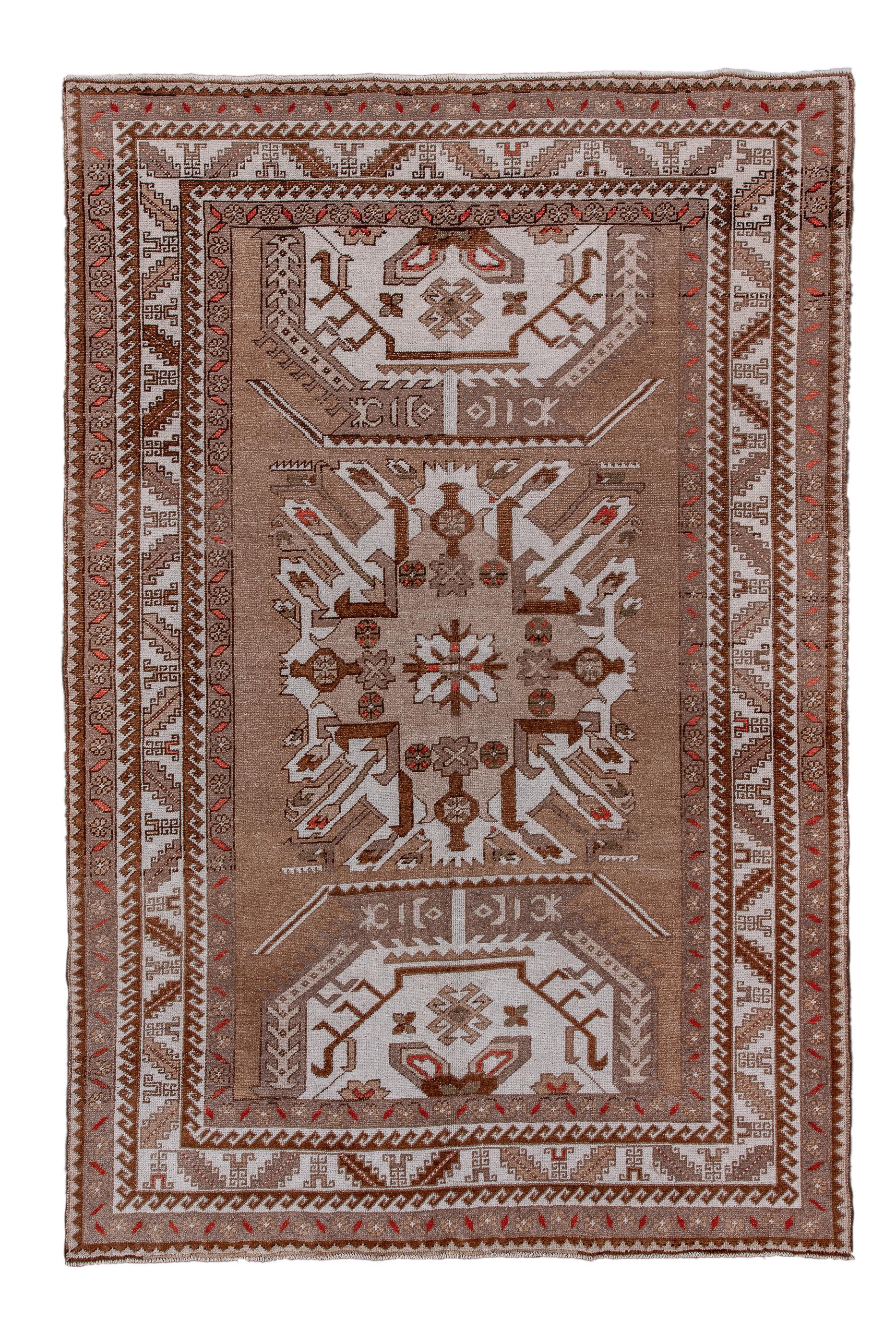 From an outlying bit of the Kazak area, this Turkish large scatter rug shows a simplified version of the “Eagle Kazak” with a characteristic radiating ecru medallion supported by half octagon motives above and below, on a coral ground. Cream strip