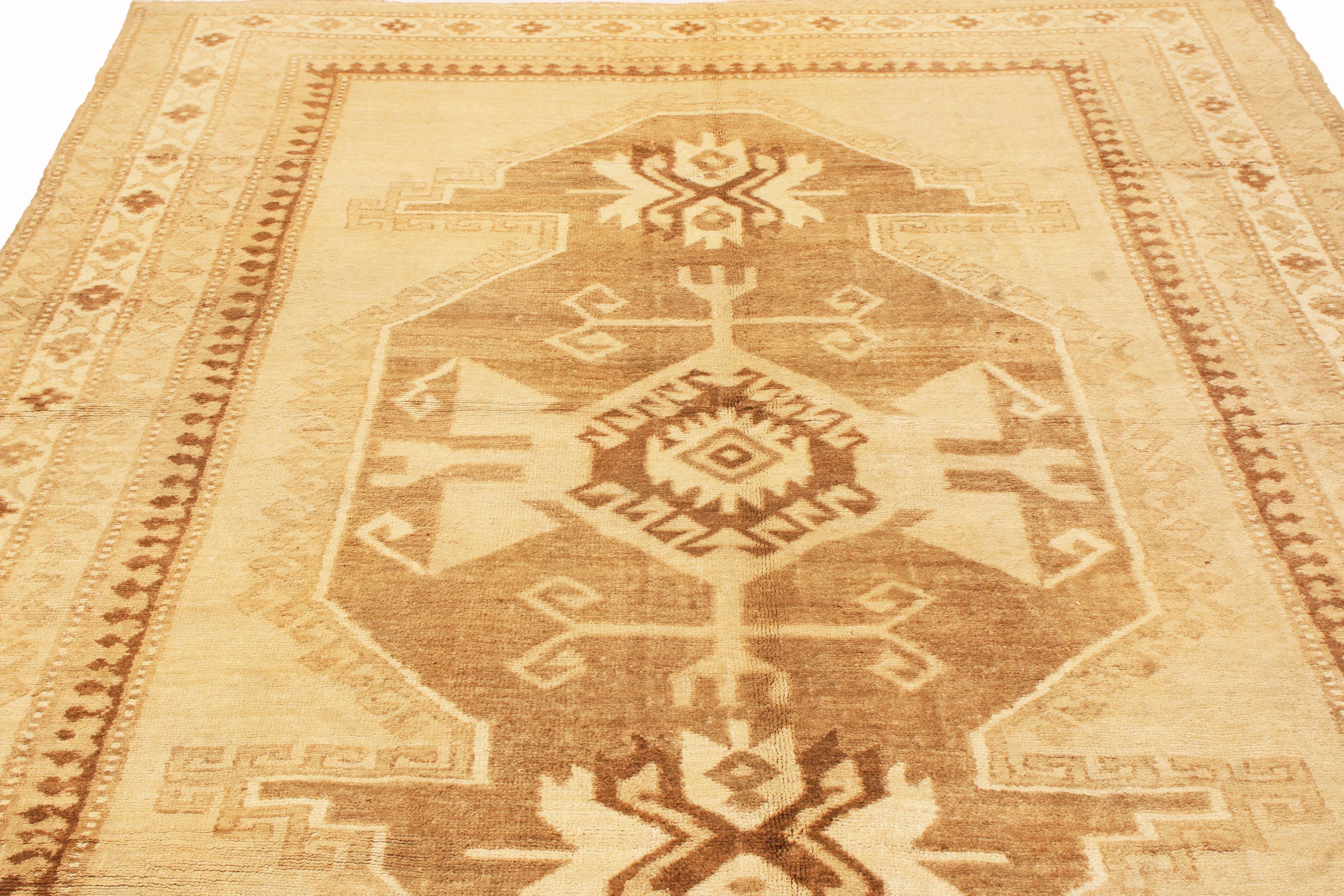 Originating from Turkey in 1960, this vintage transitional Kars hand knotted wool rug features a medallion style field design, sporting a wide variety of symbols including double rams horns signifying strength and masculinity, mirrored hooks for