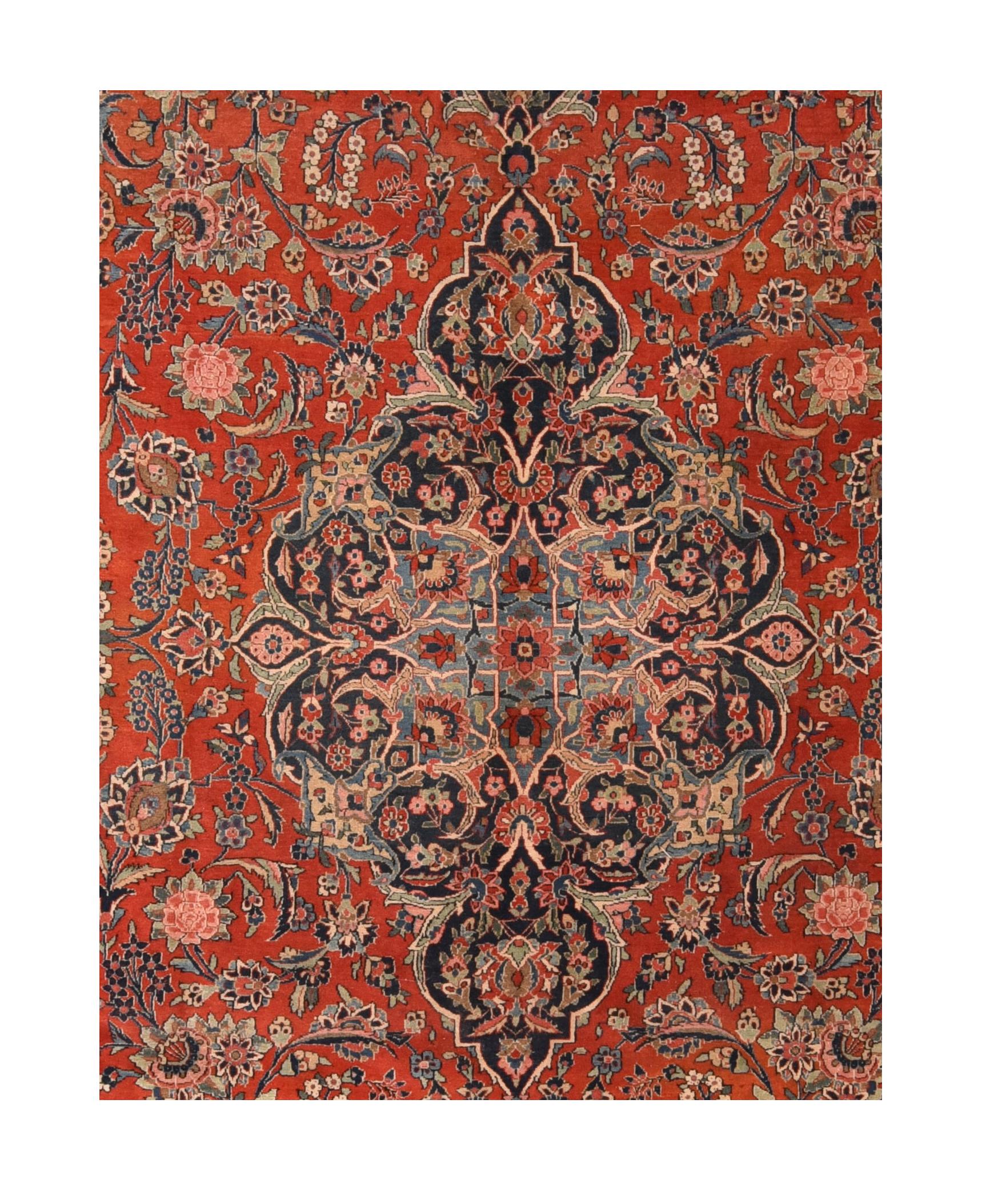 Vintage Kashan Rug¬†8'10'' x 12'2''. Iconic 30's piece with a medium red field decorated by rosettes, palmettes and various leaves, and centred by a navy pendanted medallion. Navy and green corners with tilted vases. Navy border with floriated