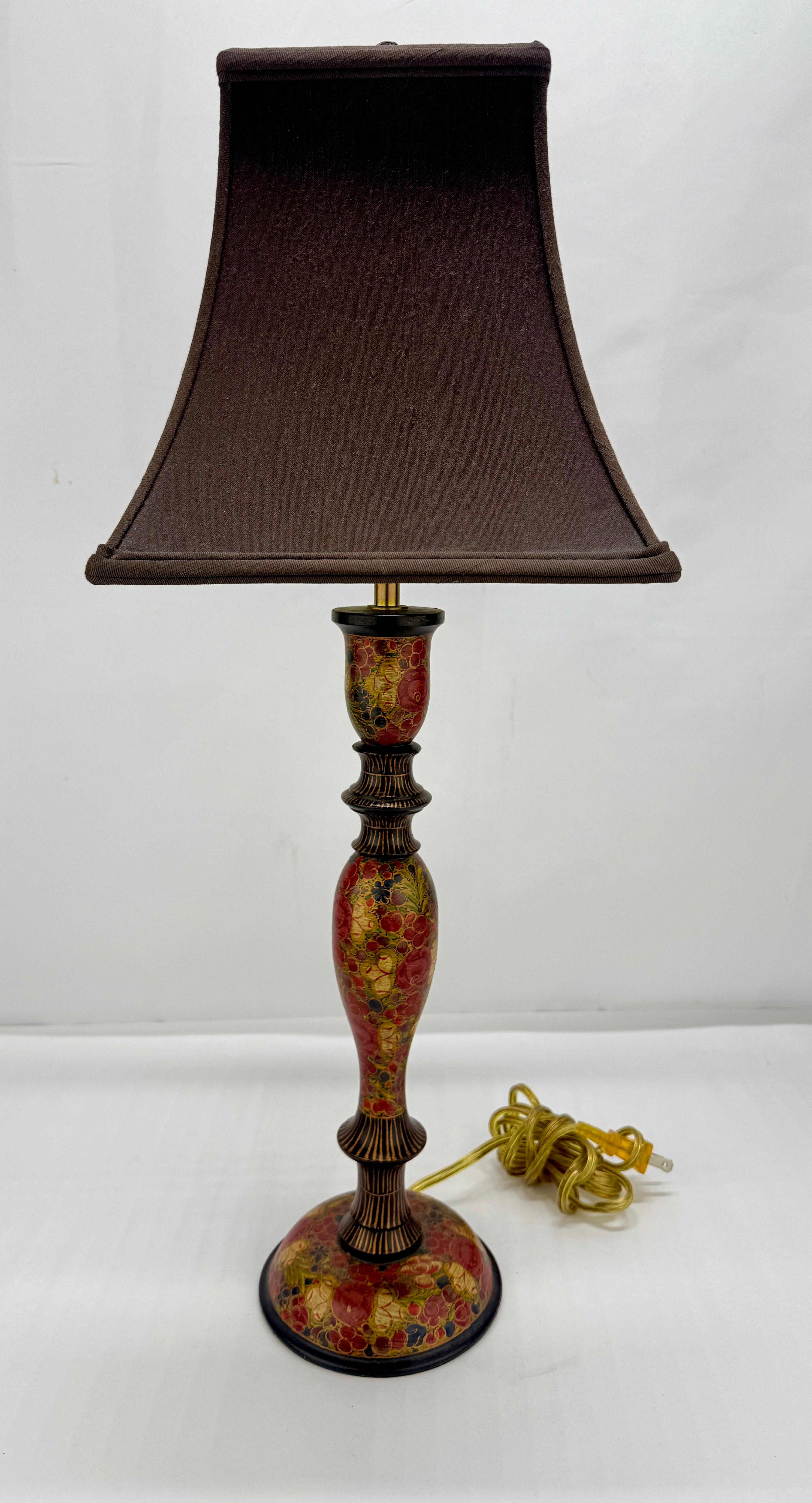 Una lampada da tavolo alta, a forma di balaustro, riccamente decorata secondo la tradizione naqashi del Kashmir. Lo stendardo è realizzato in cartapesta laccata (su un'anima tornita), dipinta a mano con densi millefleurs - papaveri, chinar e bacche