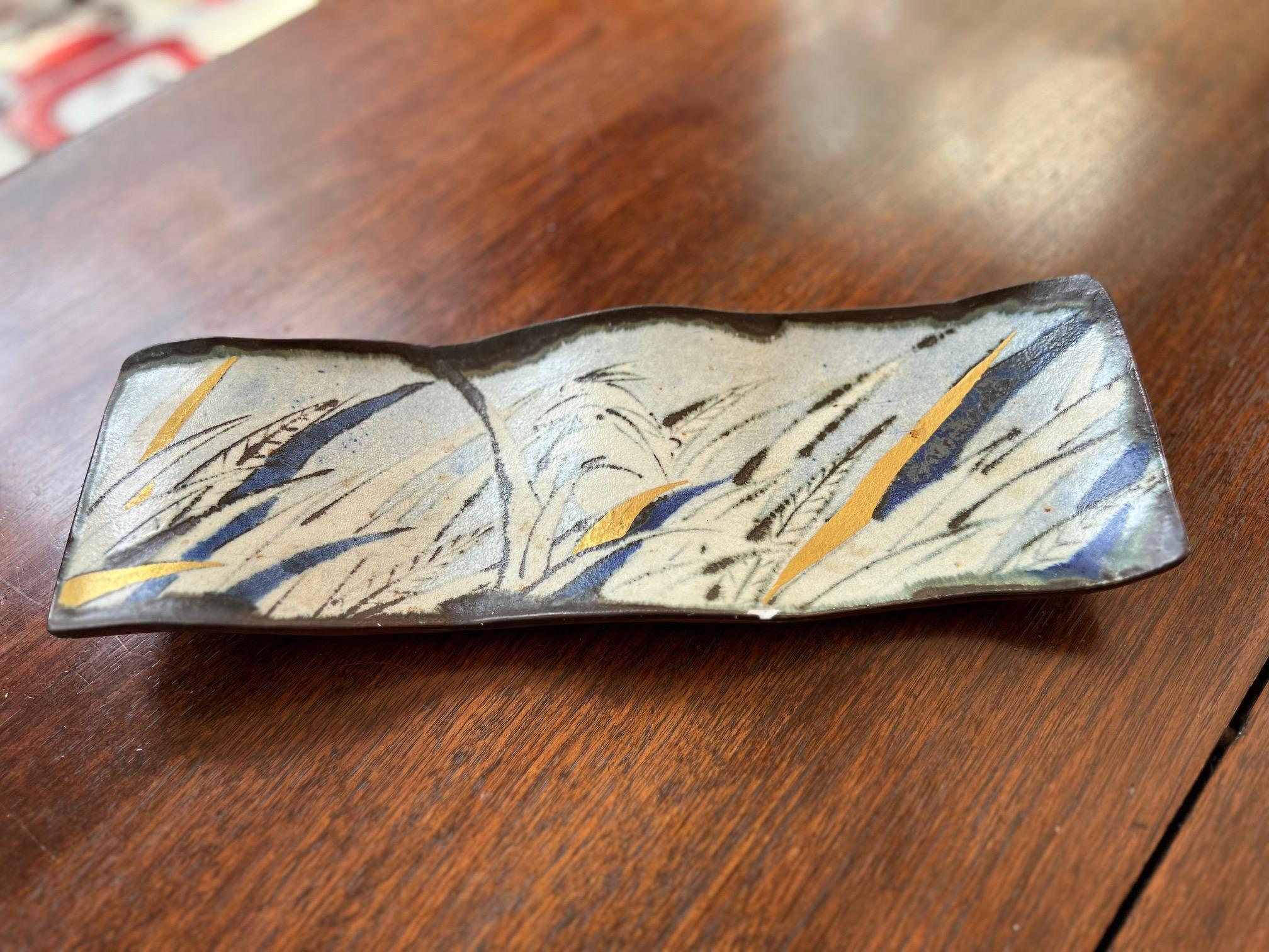 Kazu Yoneda (1949-), Japanese. A ceramic tray, signed and labeled on underside.

The tray has a gently curved, wave-like form, which gives it a natural, fluid appearance. The upper surface of the dish is decorated with a beautiful abstract design