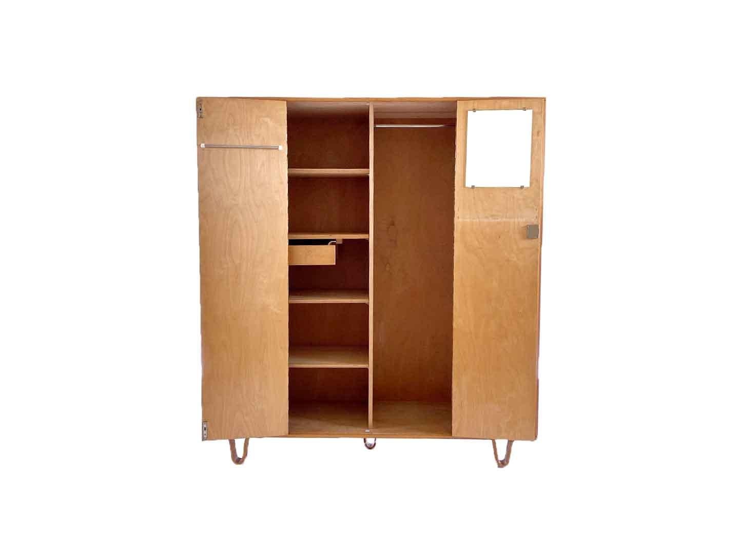 Very particularly iconic vintage kb04 wardrobe by Cees Braakman, produced by Pastoe in 1954. The wardrobe belongs to the Pastoe birch series and with its plywood loop legs, it is a real dutch design classic. The wardrobe has 4 doors with a hanging