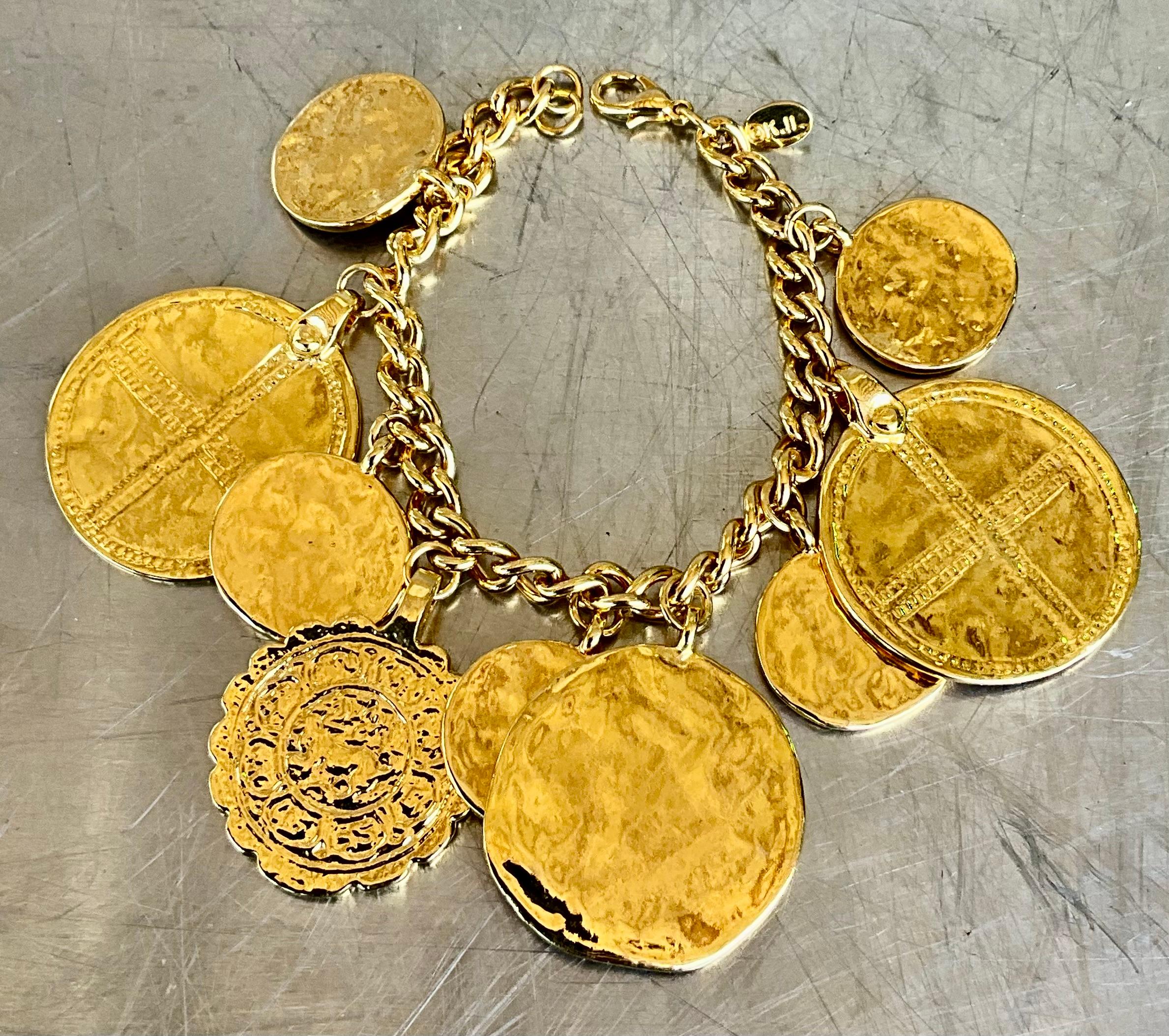 ​This Vintage Kenneth Jay Lane Acapulco Gold-Tone Medallion Charm Bracelet is a distinctive piece from the renowned designer, celebrated for his luxurious costume jewelry that emulates the elegance of fine jewelry.

This bracelet features a