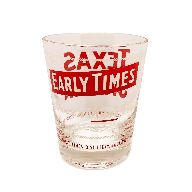 A vintage glass bourbon whiskey glass in red and white. We think this would be a great addition to a bar, or used as a vase. 

Reads at Front: 
Texas Jigger

Reads at back:
Early Times
Every Ounce a Man's Whiskey!

Reads around the