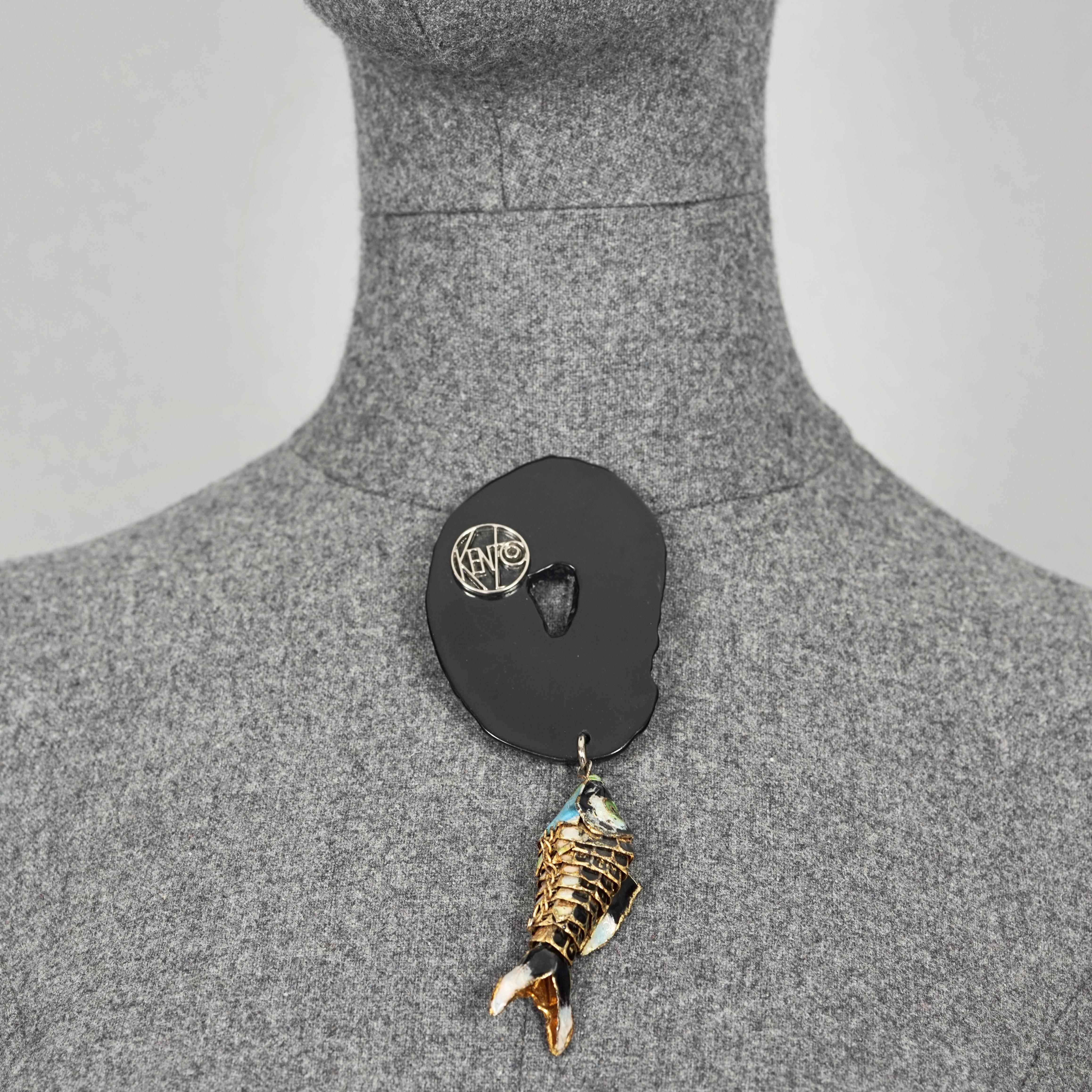 Vintage KENZO Articulated Koi Fish Faux Agate Brooch

Measurements:
Height: 5.51 inches (14 cm)
Width: 2.16 inches (5.5 cm)

Features:
- 100% Authentic KENZO.
- Black faux agate slice with dangling articulated enamel Koi fish.
- Gold and silver tone