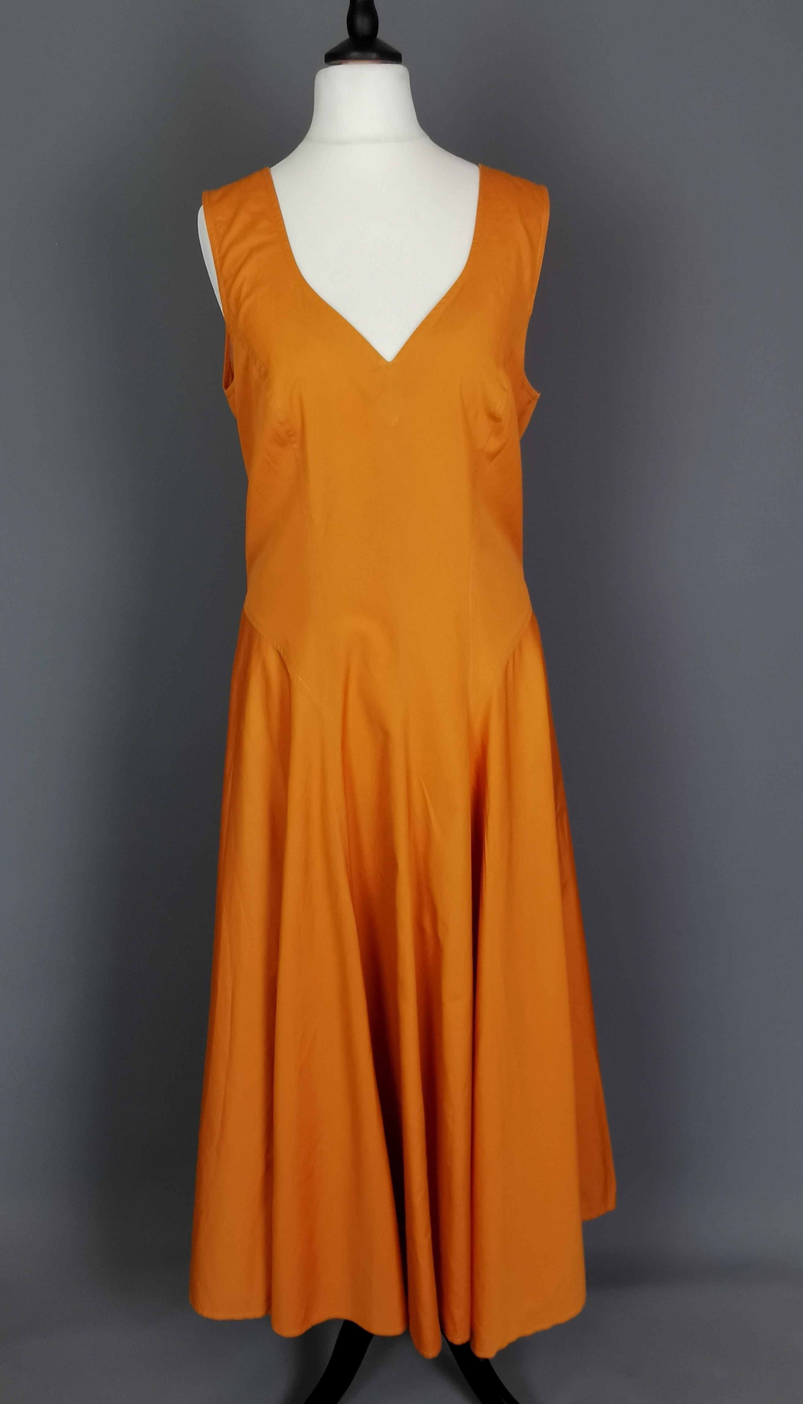 Magnifique robe de soleil vintage Kenzo orange brûlé des années 1980.

Une jolie robe d'été flottante, sans manches, avec de larges bretelles et un décolleté en C.

Elle est légèrement cintrée à la taille, avec des jupes amples et un buste