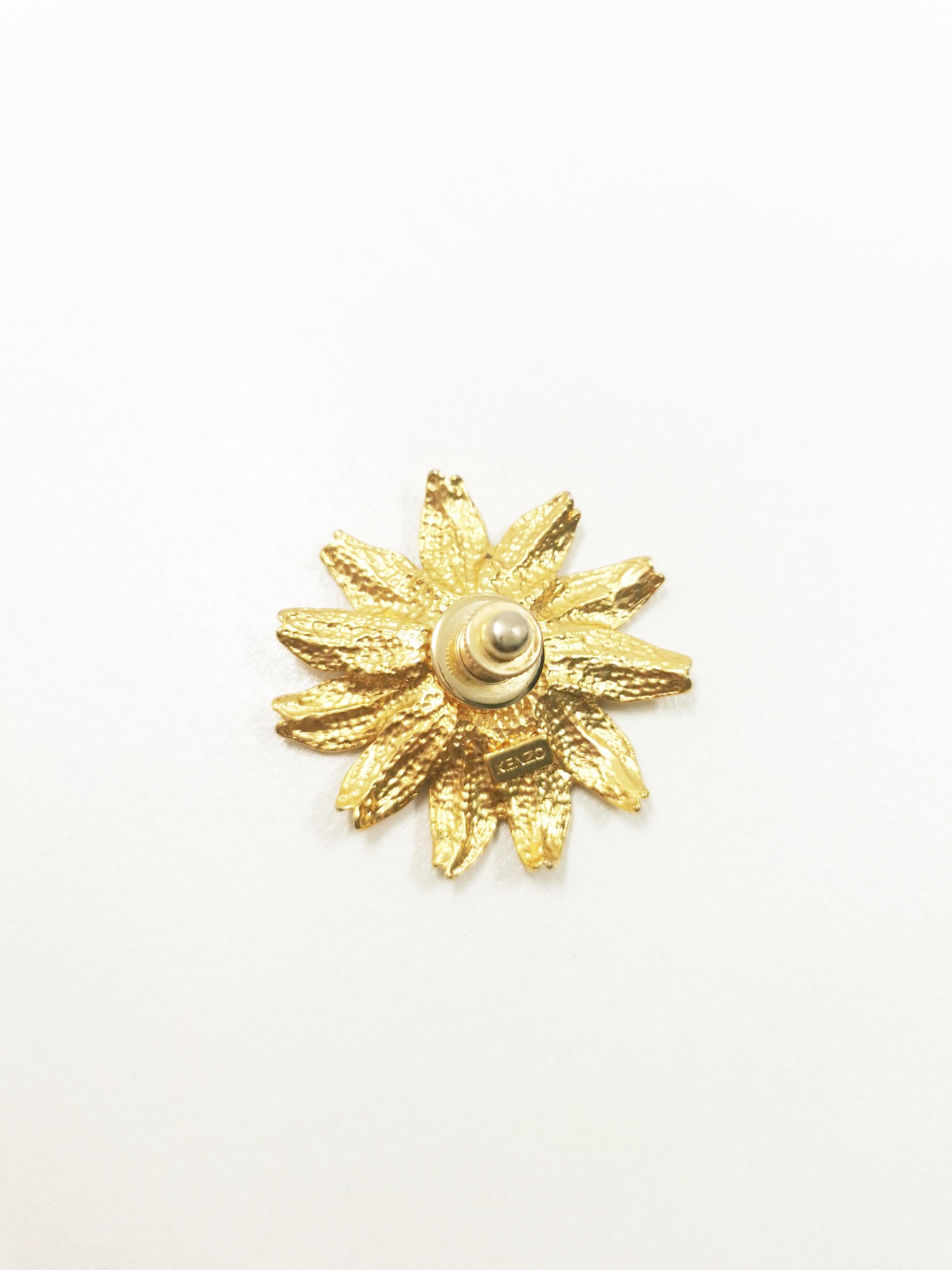 
Elevate your style with the Vintage KENZO Gerbera Flower Pin Brooch, a refined accessory that seamlessly blends the nostalgic charm of a bygone era with contemporary elegance. This exquisite brooch is a testament to KENZO's commitment to intricate