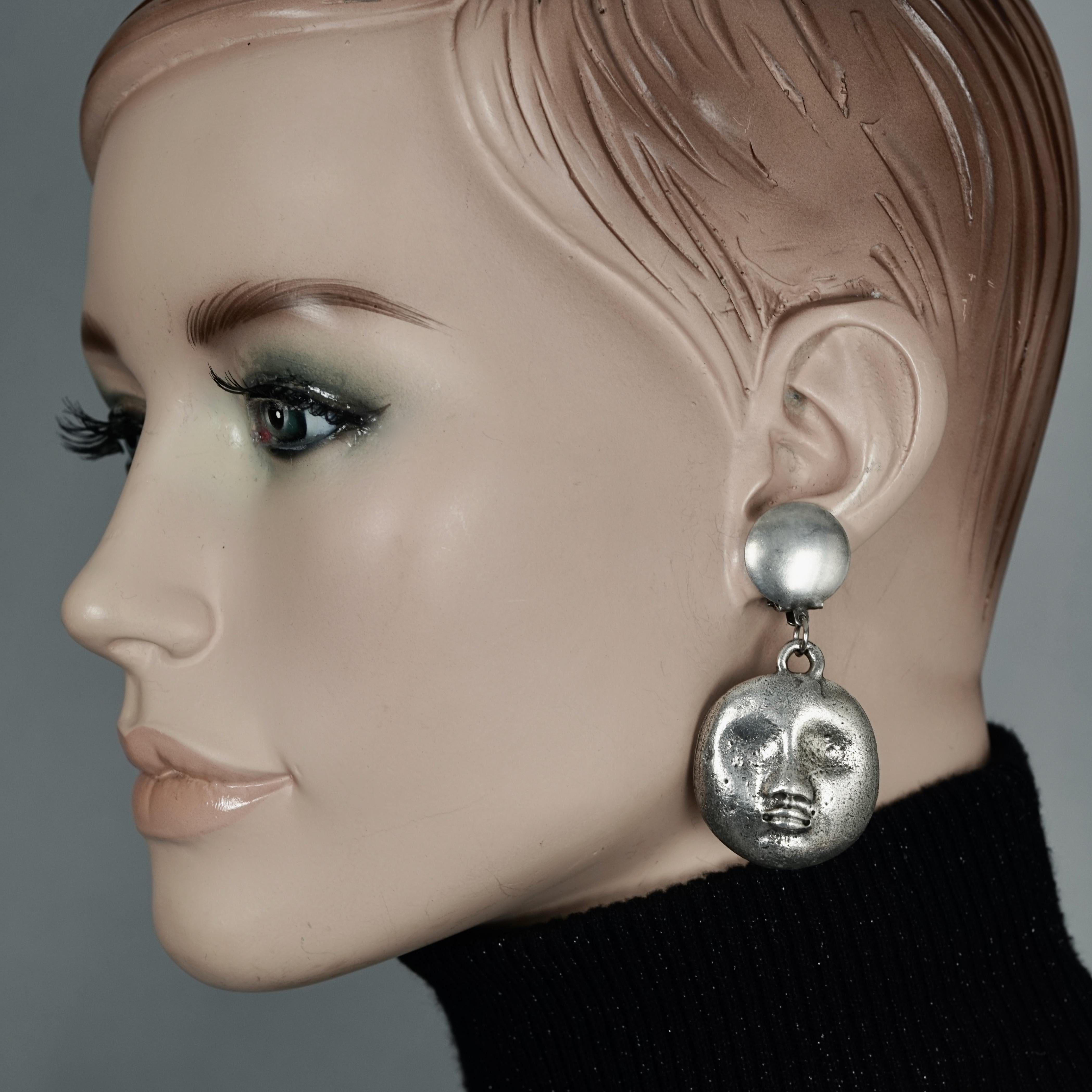Vintage KENZO PARIS Sculptured Face Dangling Earrings

Measurements:
Height: 2.44 inches (6.2 cm)
Width: 1.26 inches (3.2 cm)
Weight per Earring: 11 grams

Features:
- 100% Authentic KENZO PARIS.
- Sculptured face dangling earrings.
- Silver tone