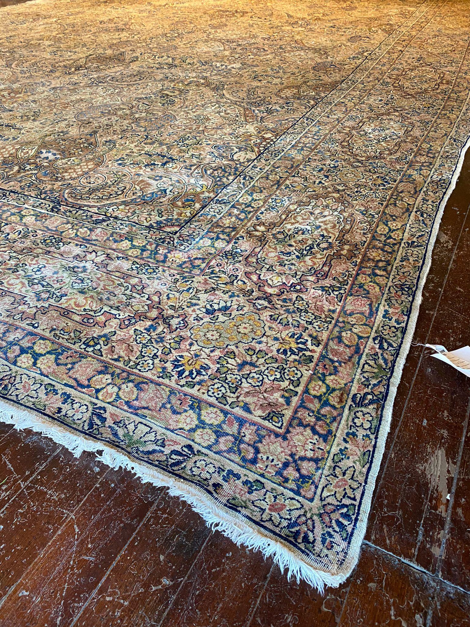 This Kerman Persian rug boasts a classic and intricate design that is characteristic of Persian craftsmanship. Measuring 11 feet in width by 15 feet 6 inches in length, it is generously sized, making it suitable for larger living spaces or grand