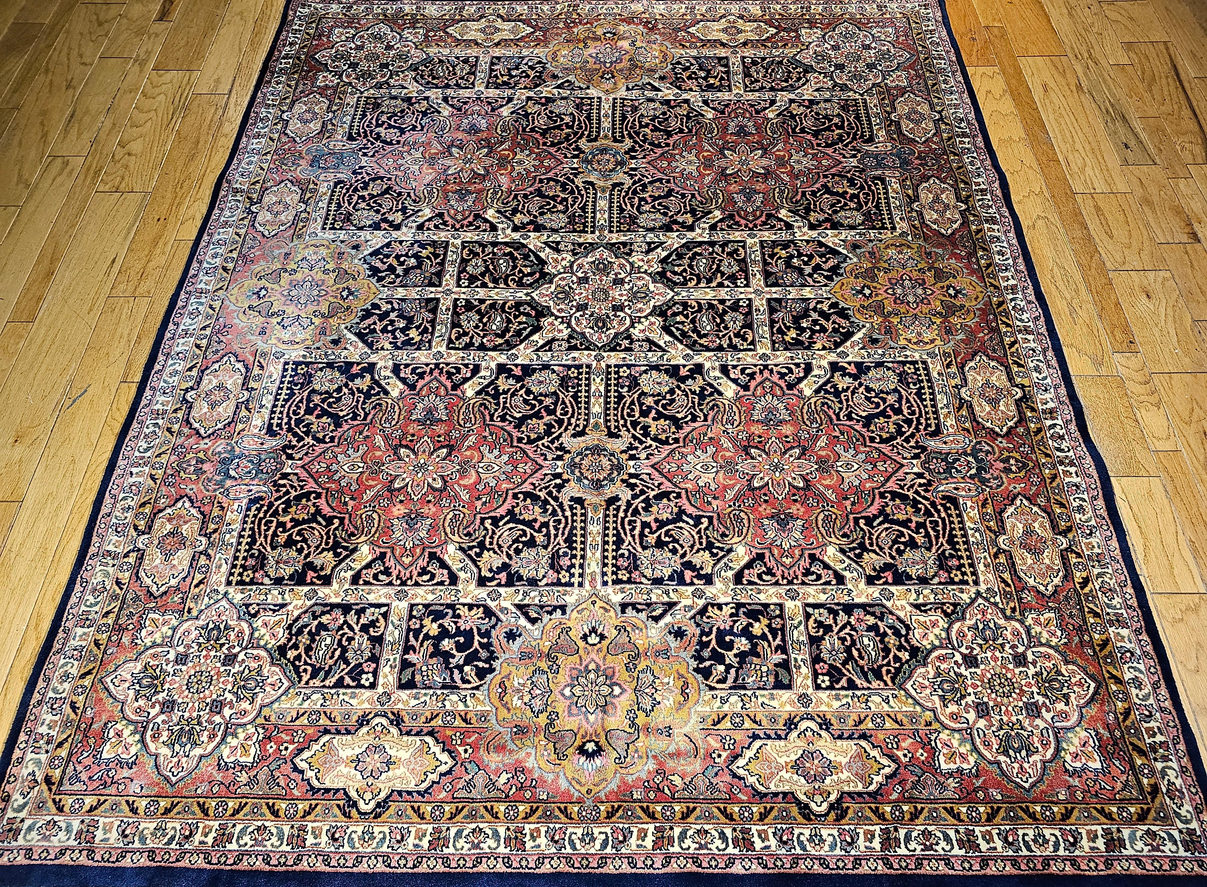 Vintage Kerman style room size rug from the late 20th century.  The rug has a beautiful all-over large format geometric design pattern similar to the Persian Kerman rugs from the 19th century. The background color is dark navy blue/black with