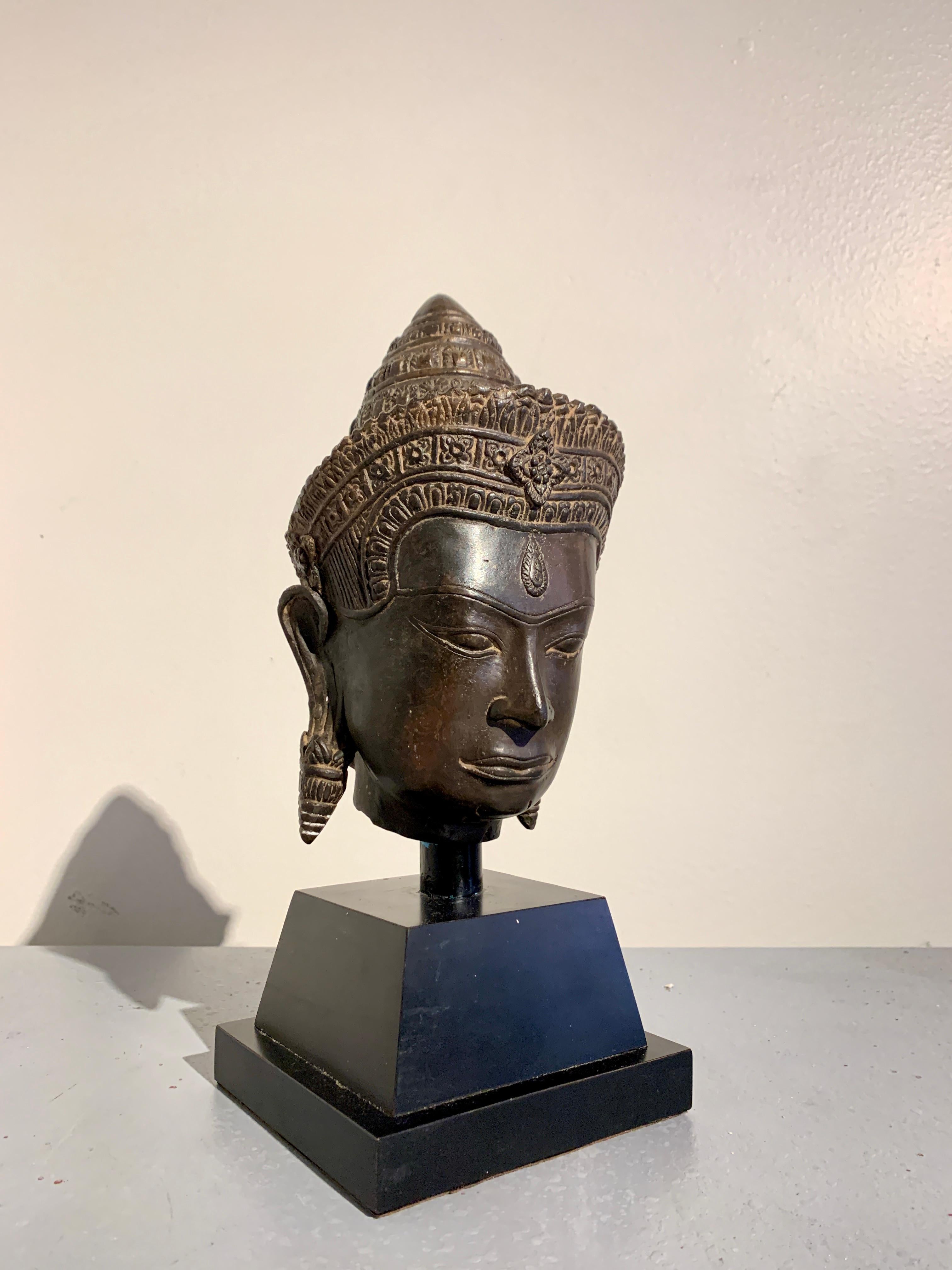 A well cast vintage Khmer, Angkor Wat style, bronze head of Shiva, circa 1970's, Thailand.

Shiva, the Hindu god of creation, change and destruction, is identified by the third eye in the center of his forehead. His highly stylized face features